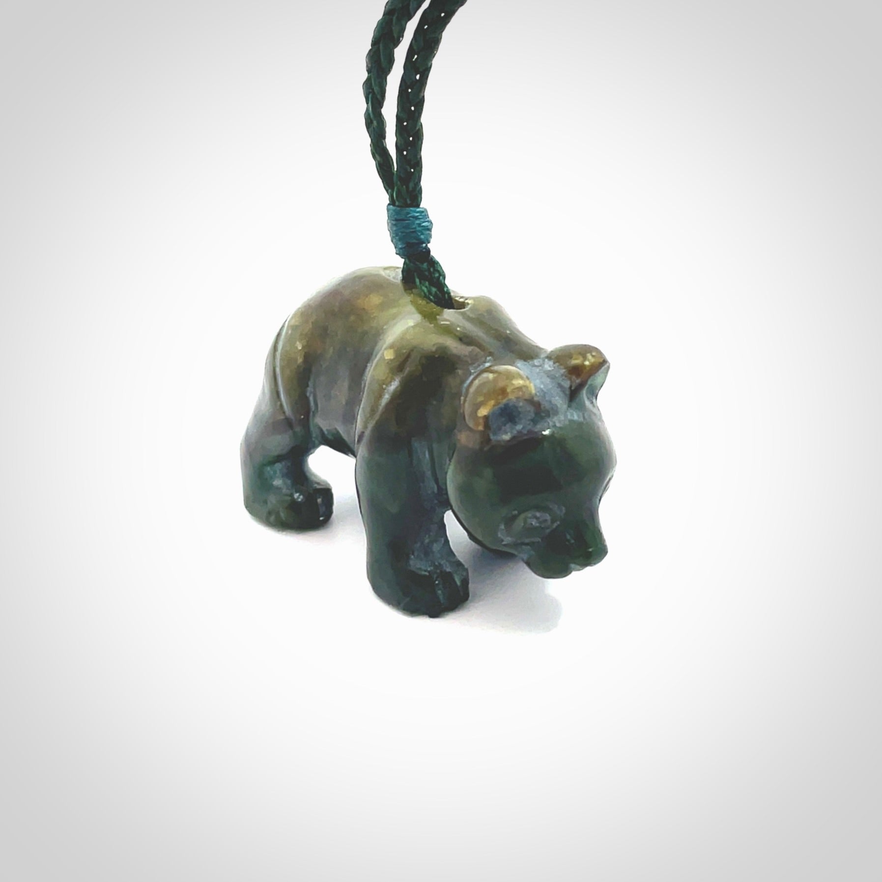 This picture shows a pendant that we designed in New Zealand jade. It is a little green bear that has a walking stance and is carved in detail. A really attractive and eye-catching piece of handmade jewellery. The cord is hand plaited braid in manuka green and the length can be adjusted.