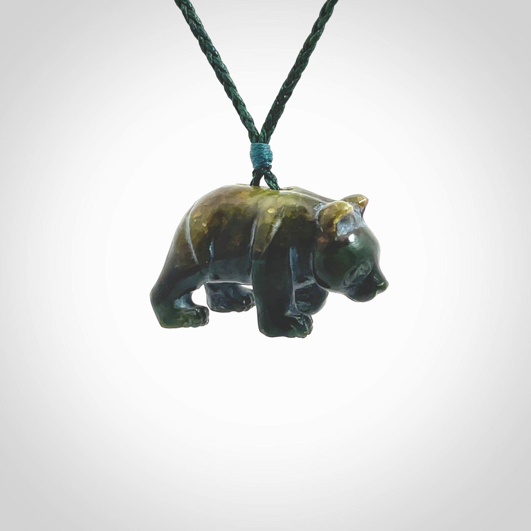 This picture shows a pendant that we designed in New Zealand jade. It is a little green bear that has a walking stance and is carved in detail. A really attractive and eye-catching piece of handmade jewellery. The cord is hand plaited braid in manuka green and the length can be adjusted.