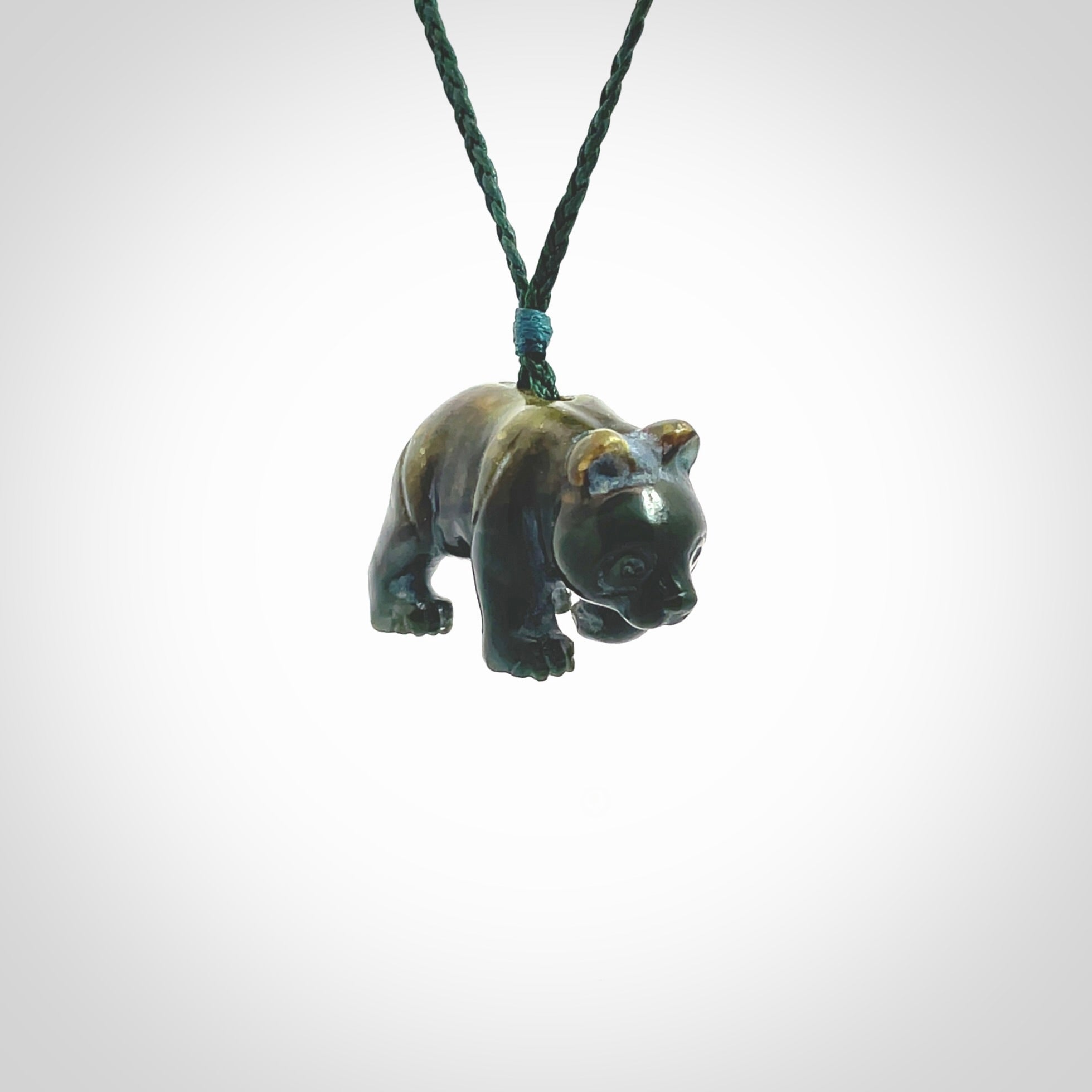 This picture shows a pendant that we designed in New Zealand jade. It is a little green bear that has a walking stance and is carved in detail. A really attractive and eye-catching piece of handmade jewellery. The cord is hand plaited braid in manuka green and the length can be adjusted.