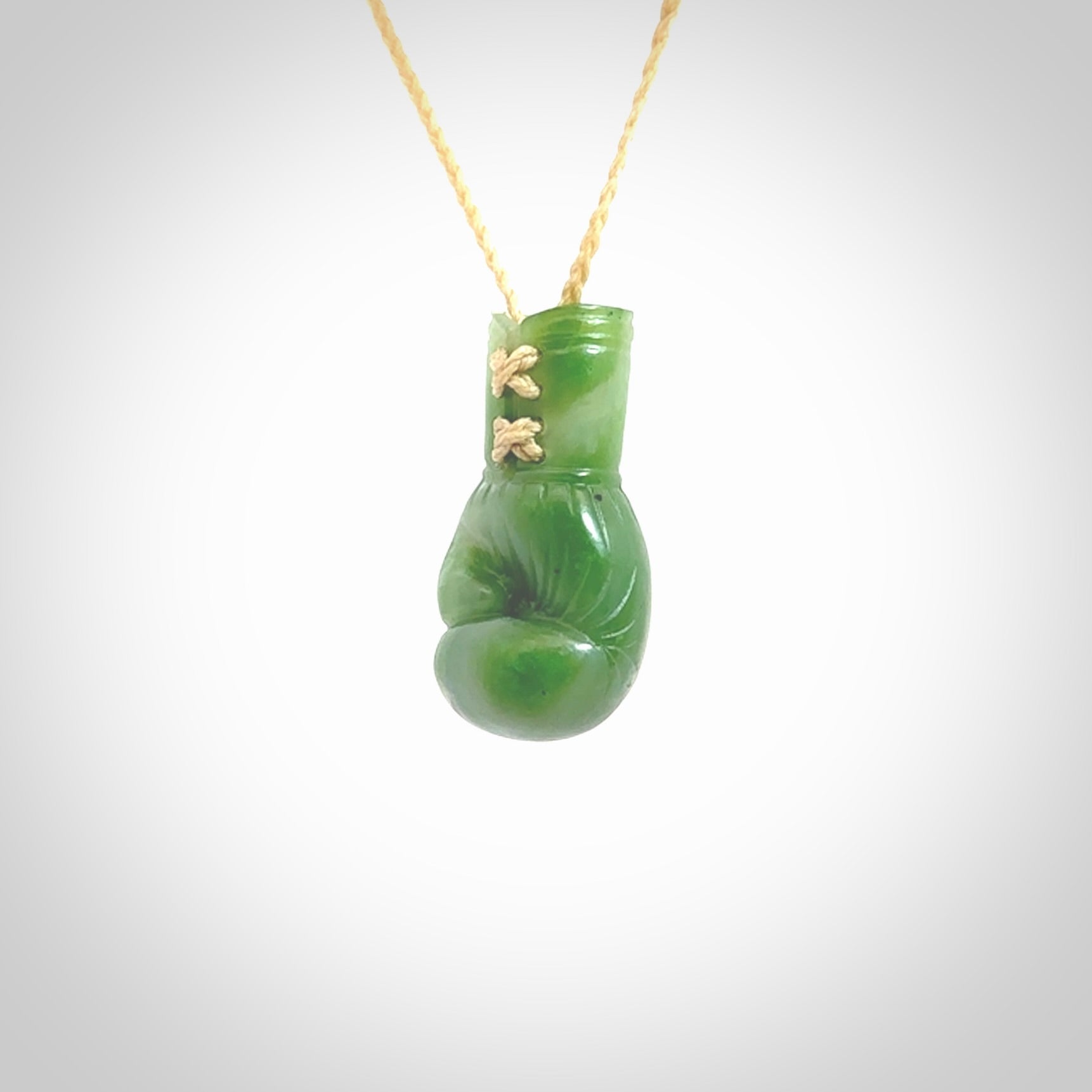 Hand carved boxing glove made from New Zealand Jade. The cord is adjustable so that you can wear this where it suits you best. We have bound these with a Oat coloured cord which contrasts with the green of the jade glove. The cost of shipping worldwide is included in the price.