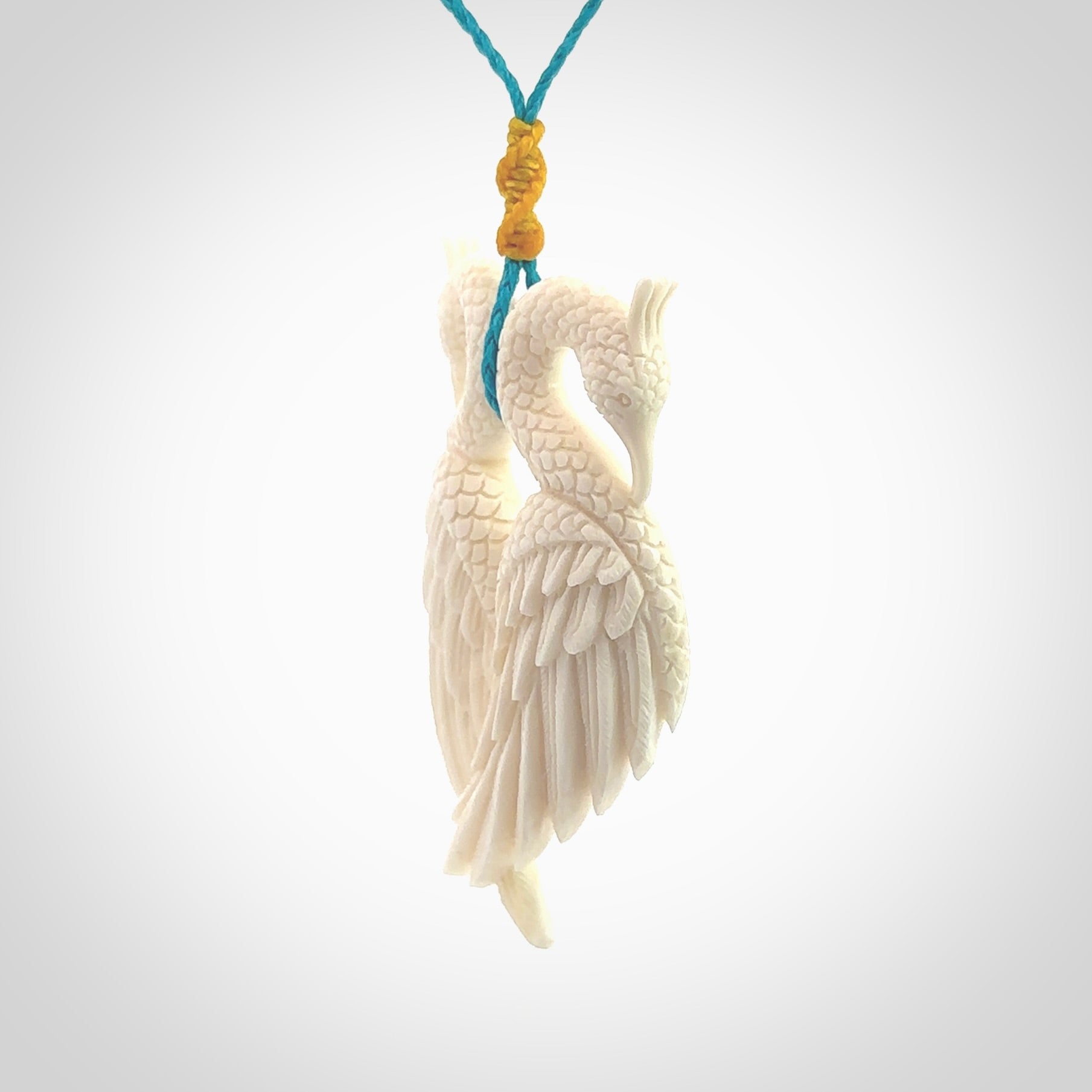 Hand carved stellar intricate double peacock carving. A stunning work of art. This pendant was hand carved in Bone. A one off peacock carving that has been hand crafted to be worn. Delivered with a paradise blue adjustable cord.