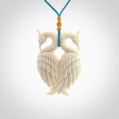 Hand carved stellar intricate double peacock carving. A stunning work of art. This pendant was hand carved in Bone. A one off peacock carving that has been hand crafted to be worn. Delivered with a paradise blue adjustable cord.