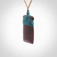 This is a beautiful hand carved Red Jasper Stone toki pendant. A really cool piece that is made from this rare and beautiful material. The red jasper has a very distinctive look and each piece is different. We ship this worldwide and the cost of shipping is included in the price. Provided with adjustable cords and packaged in a woven kete pouch.