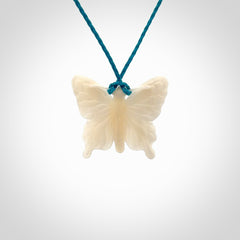 Medium sized Butterfly design pendant carved in natural bone. Real bone jewellery for sale online with NZ Pacific. Medium butterfly pendant hand made in bone, provided with paradise blue cord and packaged in a woven kete pouch.