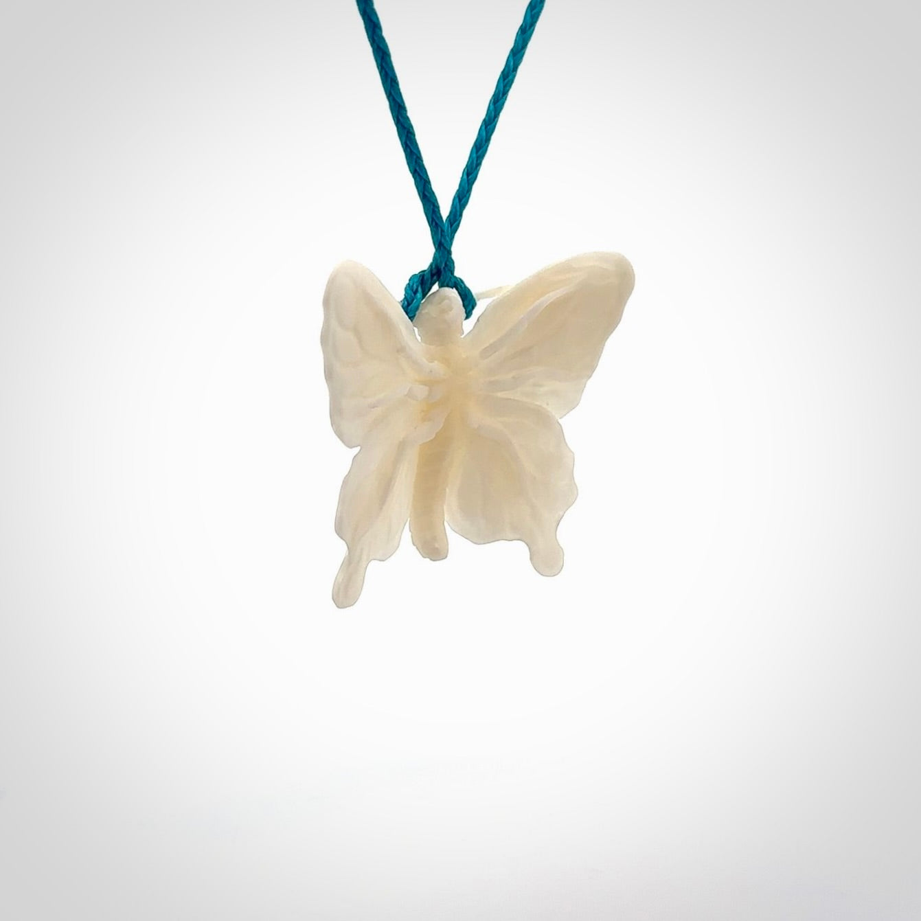 Medium sized Butterfly design pendant carved in natural bone. Real bone jewellery for sale online with NZ Pacific. Medium butterfly pendant hand made in bone, provided with paradise blue cord and packaged in a woven kete pouch.