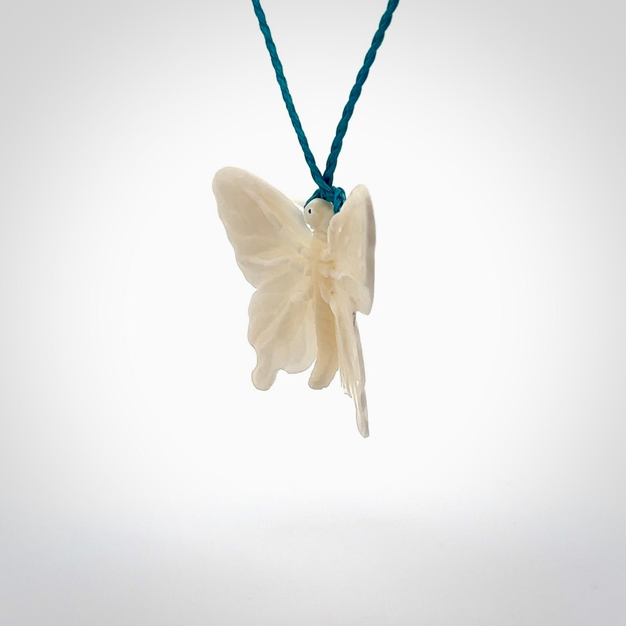 Medium sized Butterfly design pendant carved in natural bone. Real bone jewellery for sale online with NZ Pacific. Medium butterfly pendant hand made in bone, provided with paradise blue cord and packaged in a woven kete pouch.