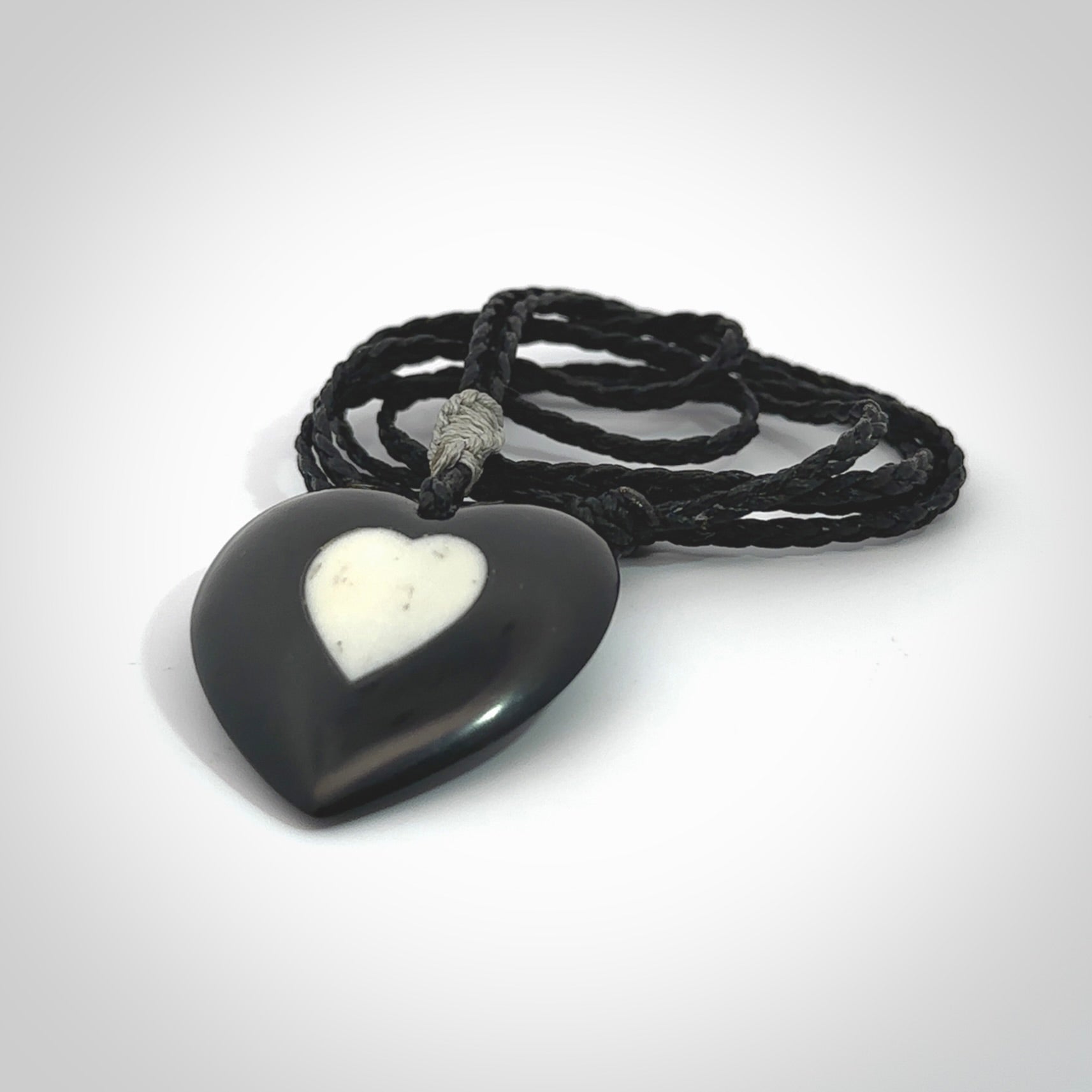 Hand carved black jade heart. Made from Australian black jade. White heart insert is carved from natural bone material. Made by NZ Pacific.