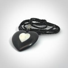 Hand carved black jade heart. Made from Australian black jade. White heart insert is carved from natural bone material. Made by NZ Pacific.