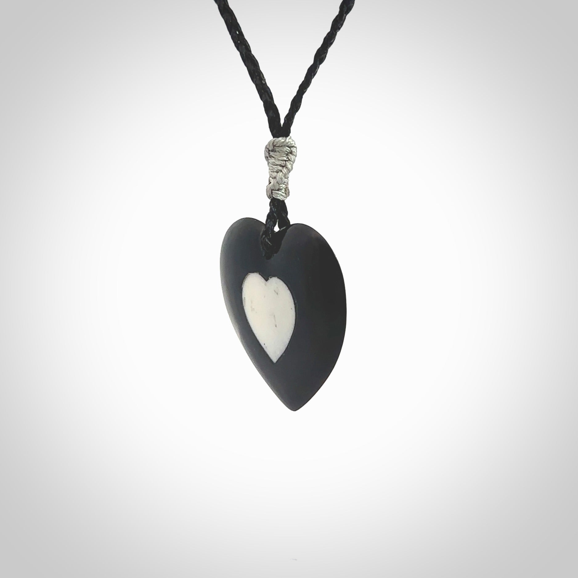 Hand carved black jade heart. Made from Australian black jade. White heart insert is carved from natural bone material. Made by NZ Pacific.