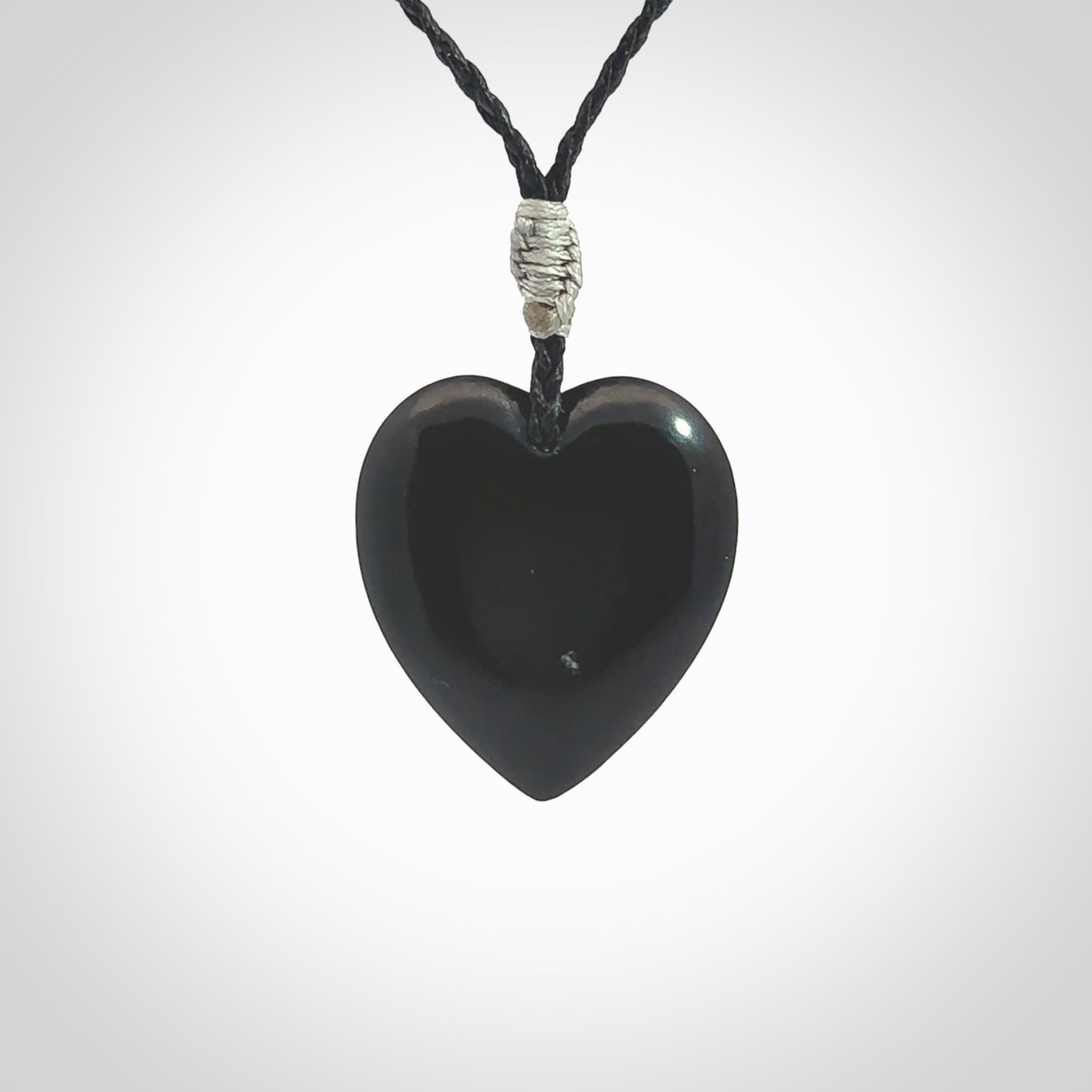 Hand carved black jade heart. Made from Australian black jade. White heart insert is carved from natural bone material. Made by NZ Pacific.