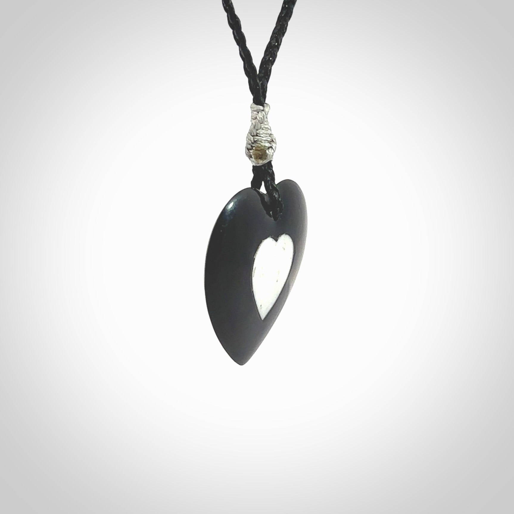 Hand carved black jade heart. Made from Australian black jade. White heart insert is carved from natural bone material. Made by NZ Pacific.