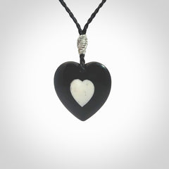 Hand carved black jade heart. Made from Australian black jade. White heart insert is carved from natural bone material. Made by NZ Pacific.