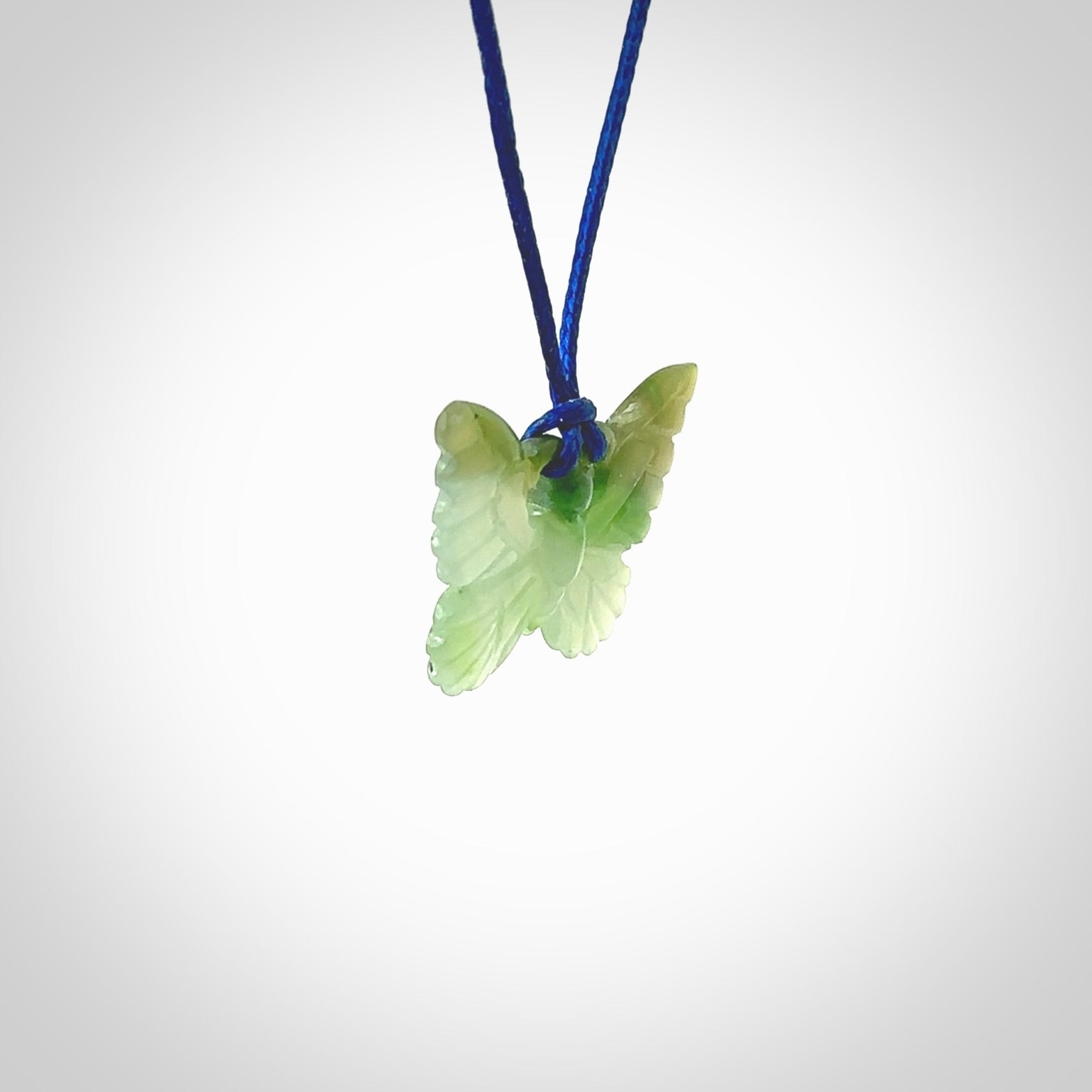 Small Butterfly design pendant carved in nephrite jade. Real jade jewellery for sale online with NZ Pacific. Small butterfly pendant hand made in Jade, provided with pacific blue cord and packaged in a woven kete pouch.