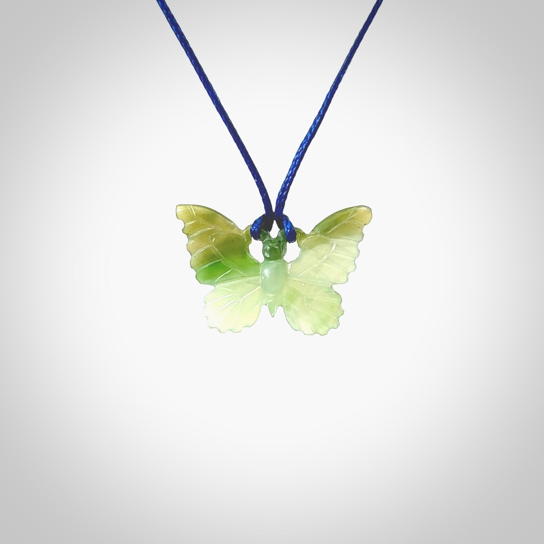 Small Butterfly design pendant carved in nephrite jade. Real jade jewellery for sale online with NZ Pacific. Small butterfly pendant hand made in Jade, provided with pacific blue cord and packaged in a woven kete pouch.