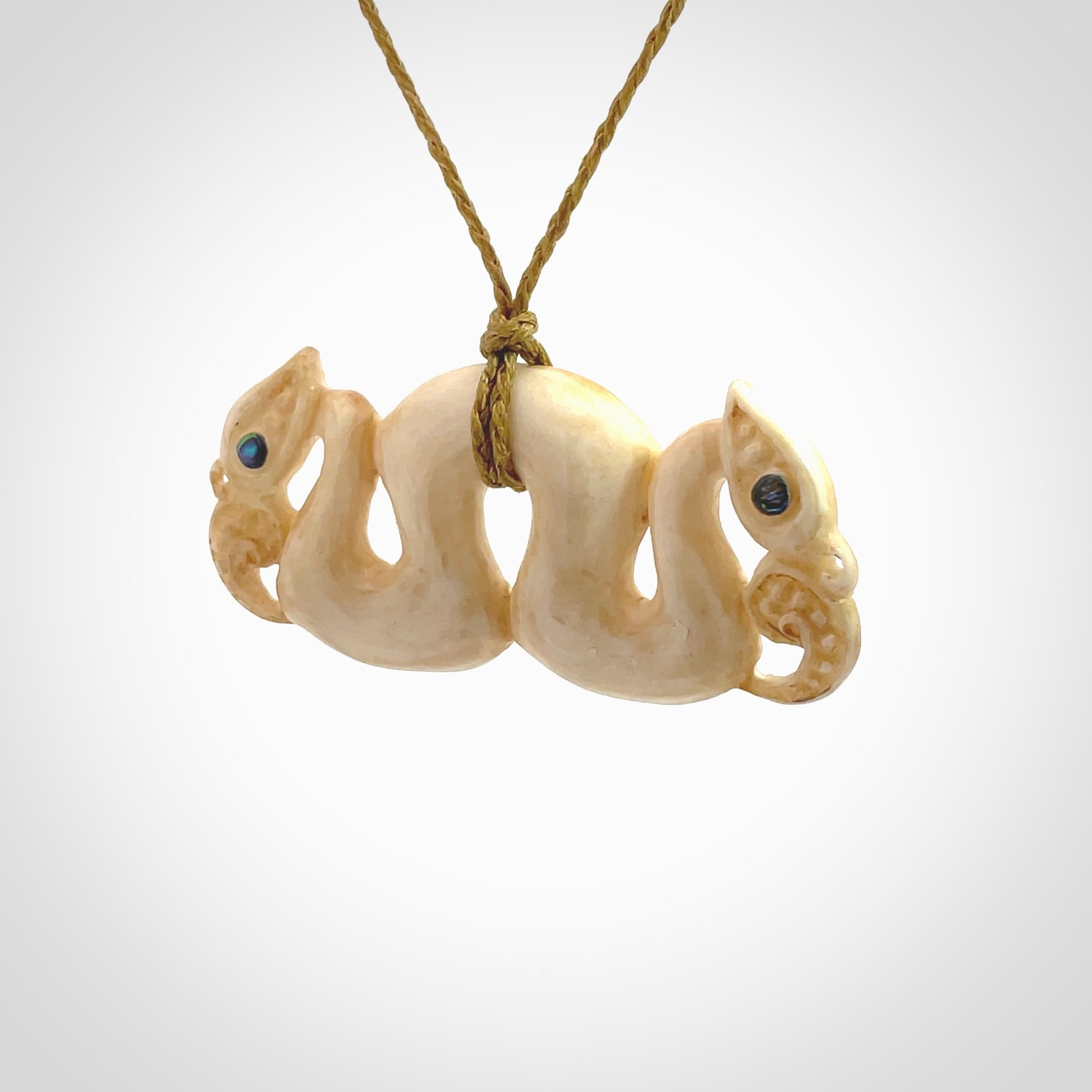 This is a unique double manaia, pekapeka, hand carved bone pendant from cow bone. The cord is sahara tan and is length adjustable. This is delivered to you with Express Courier. The eyes are made from Paua shell.