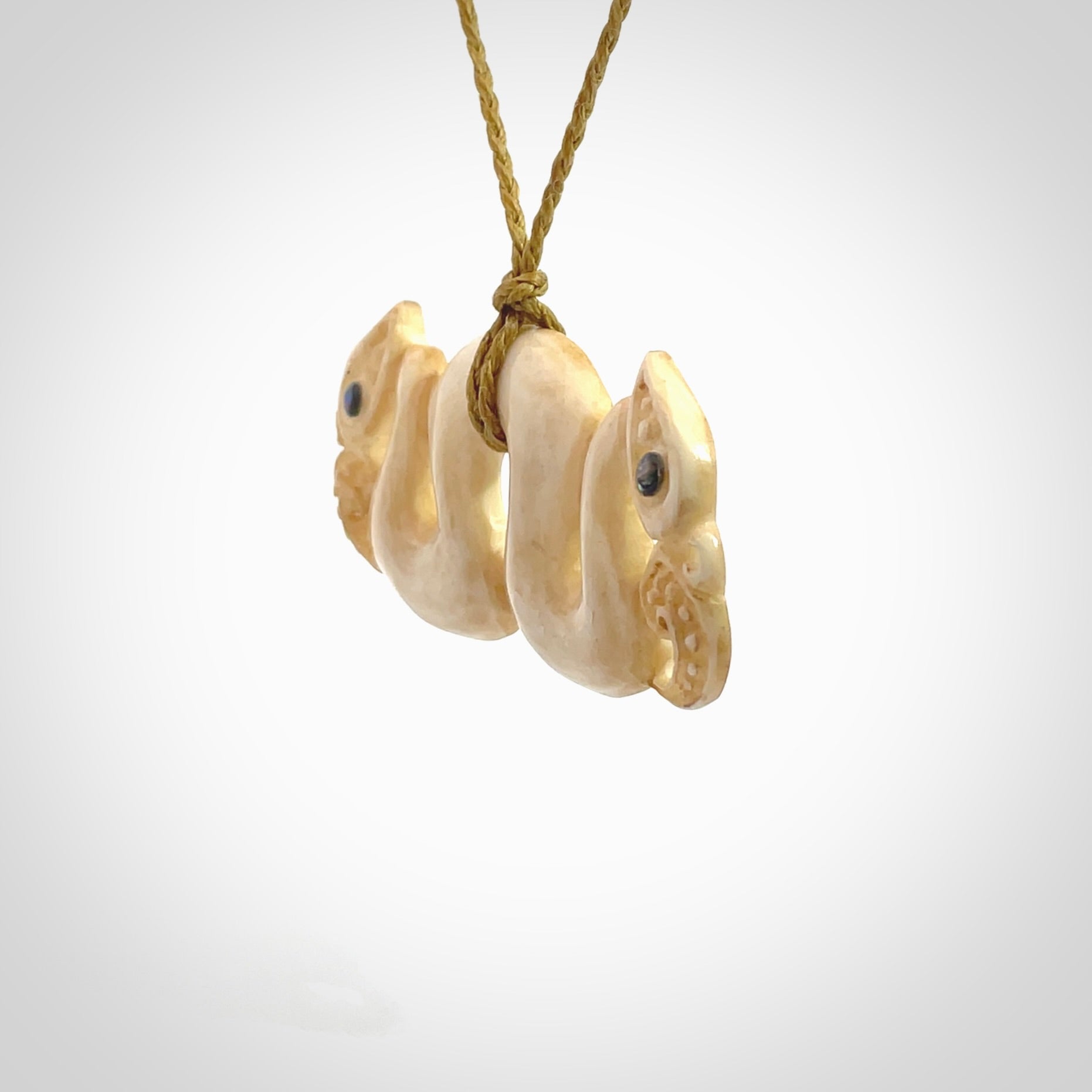 This is a unique double manaia, pekapeka, hand carved bone pendant from cow bone. The cord is sahara tan and is length adjustable. This is delivered to you with Express Courier. The eyes are made from Paua shell.