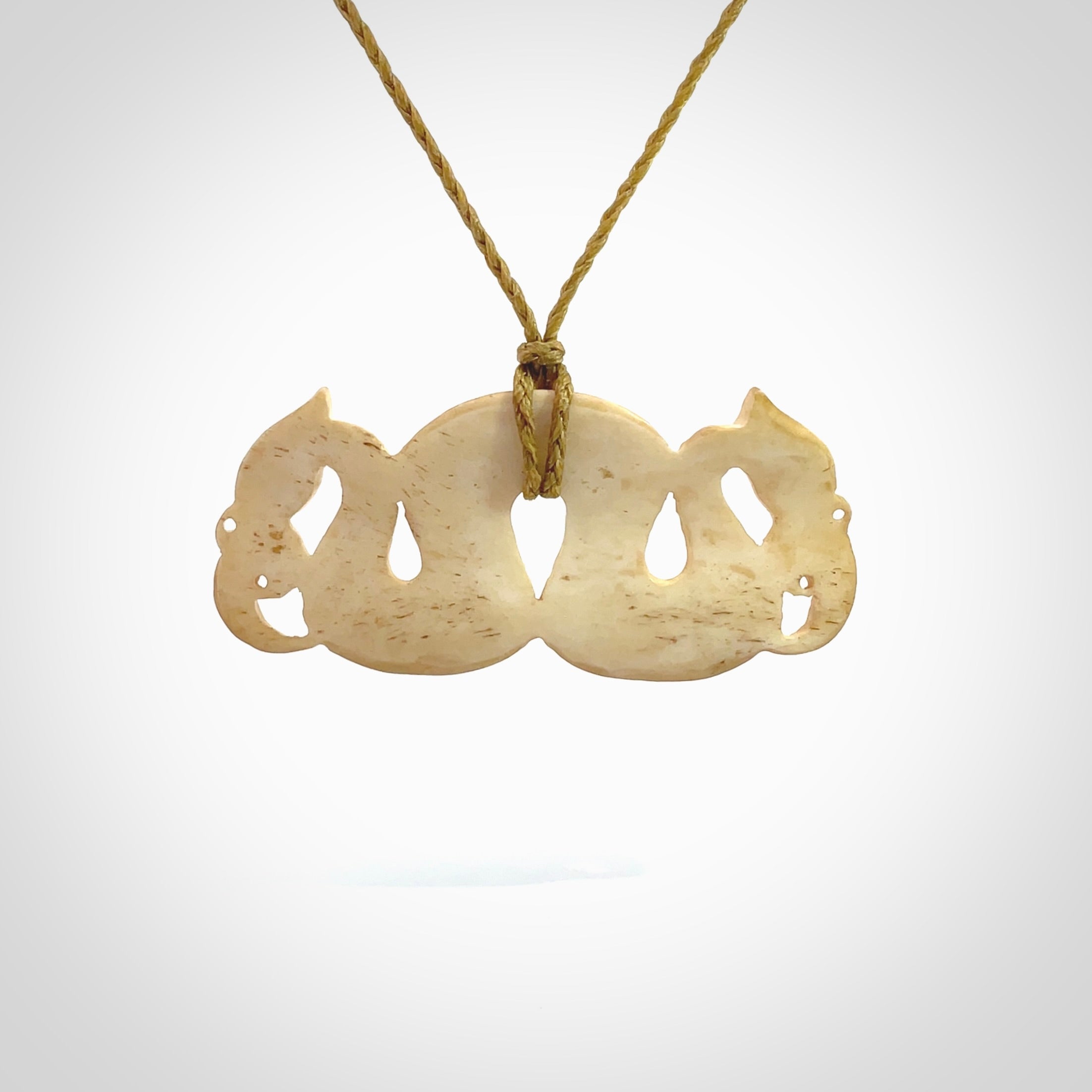 This is a unique double manaia, pekapeka, hand carved bone pendant from cow bone. The cord is sahara tan and is length adjustable. This is delivered to you with Express Courier. The eyes are made from Paua shell.