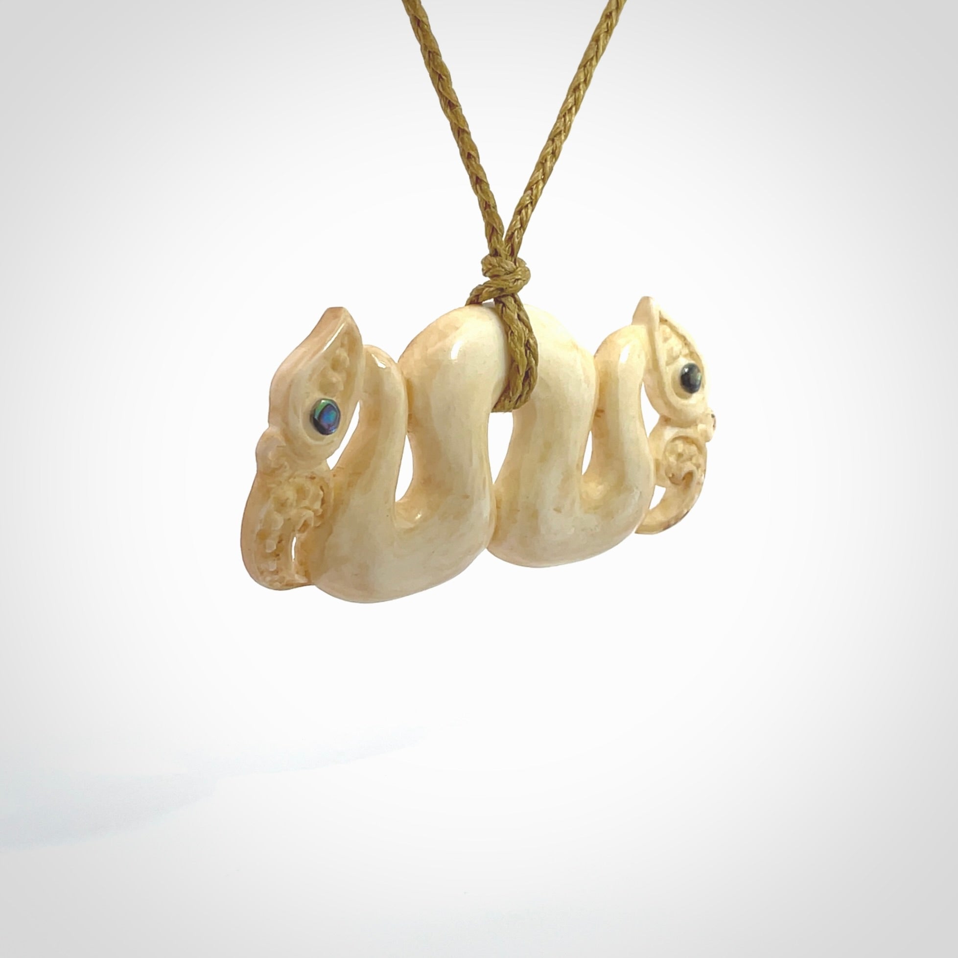 This is a unique double manaia, pekapeka, hand carved bone pendant from cow bone. The cord is sahara tan and is length adjustable. This is delivered to you with Express Courier. The eyes are made from Paua shell.