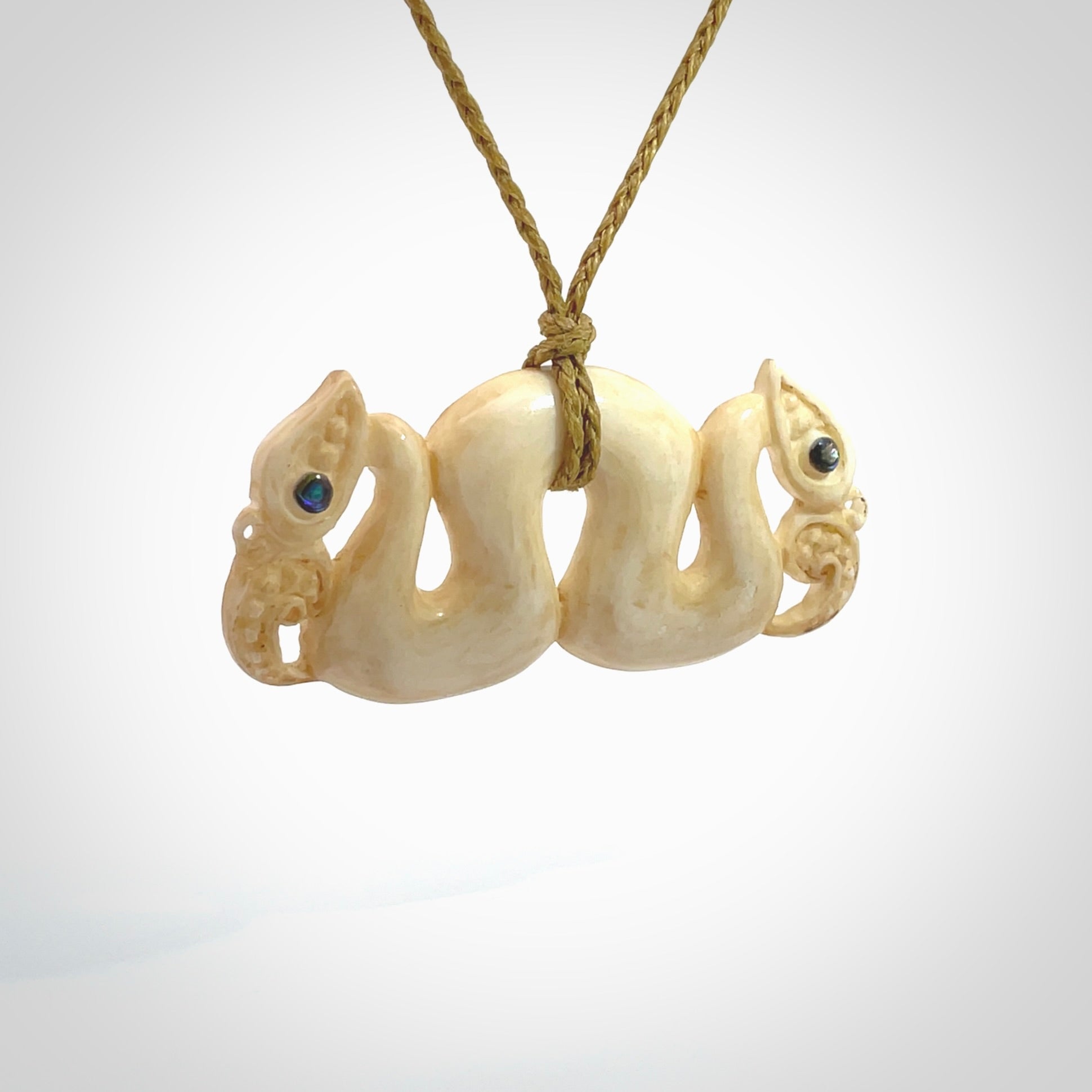 This is a unique double manaia, pekapeka, hand carved bone pendant from cow bone. The cord is sahara tan and is length adjustable. This is delivered to you with Express Courier. The eyes are made from Paua shell.