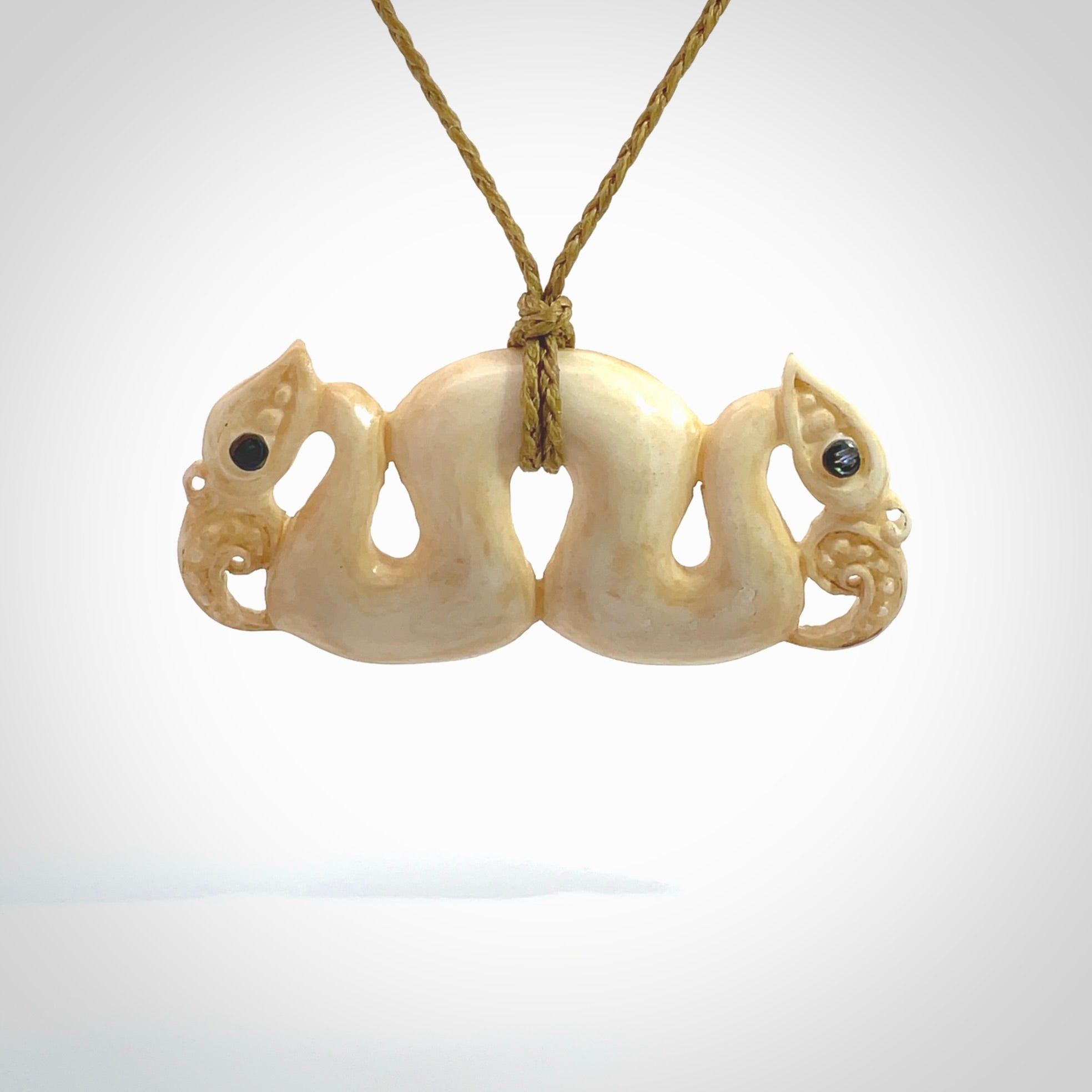 This is a unique double manaia, pekapeka, hand carved bone pendant from cow bone. The cord is sahara tan and is length adjustable. This is delivered to you with Express Courier. The eyes are made from Paua shell.