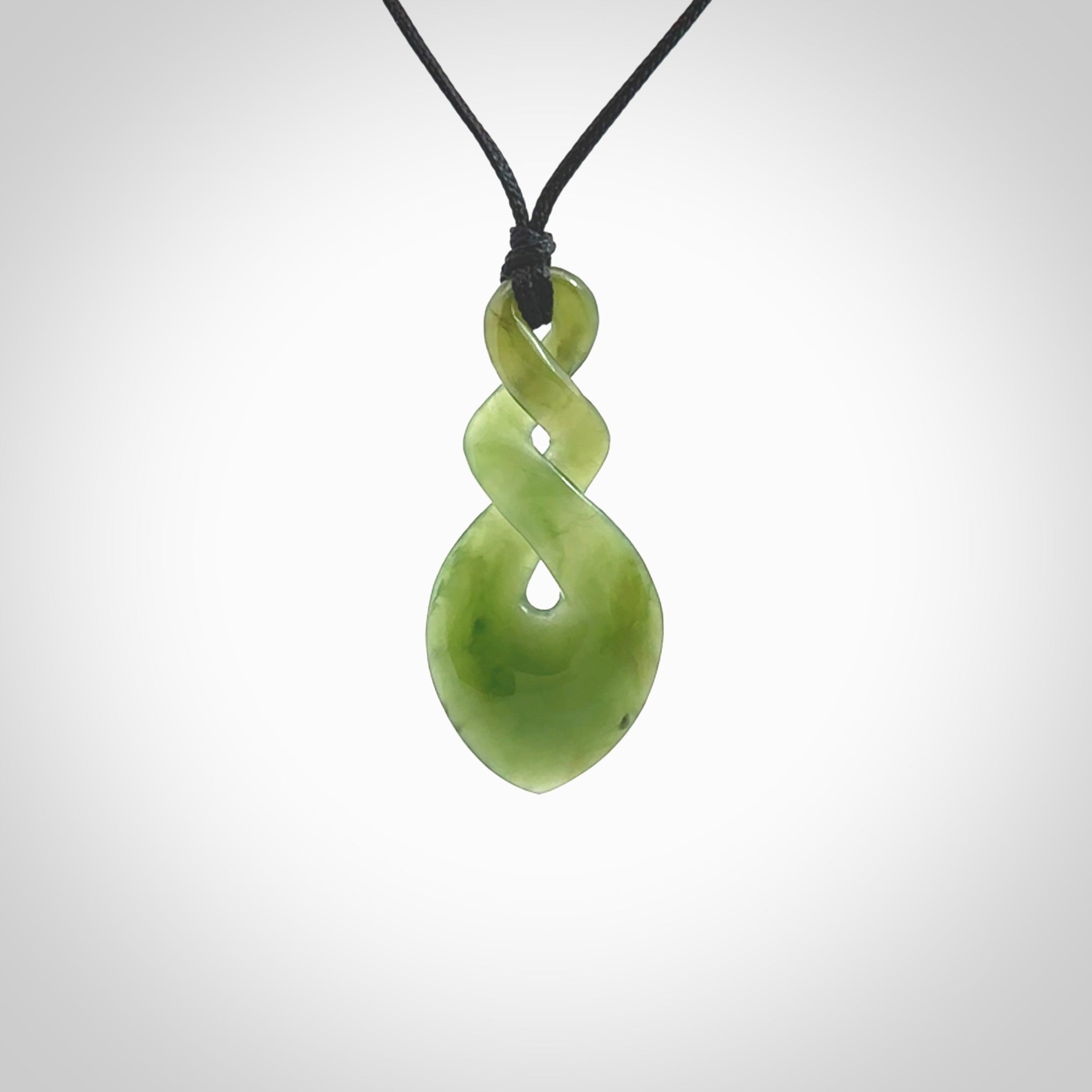 Hand carved New Zealand jade twist pendant. Carved in New Zealand by NZ Pacific. Unique double twist jewellery for sale online. Provided with an adjustable black cord.