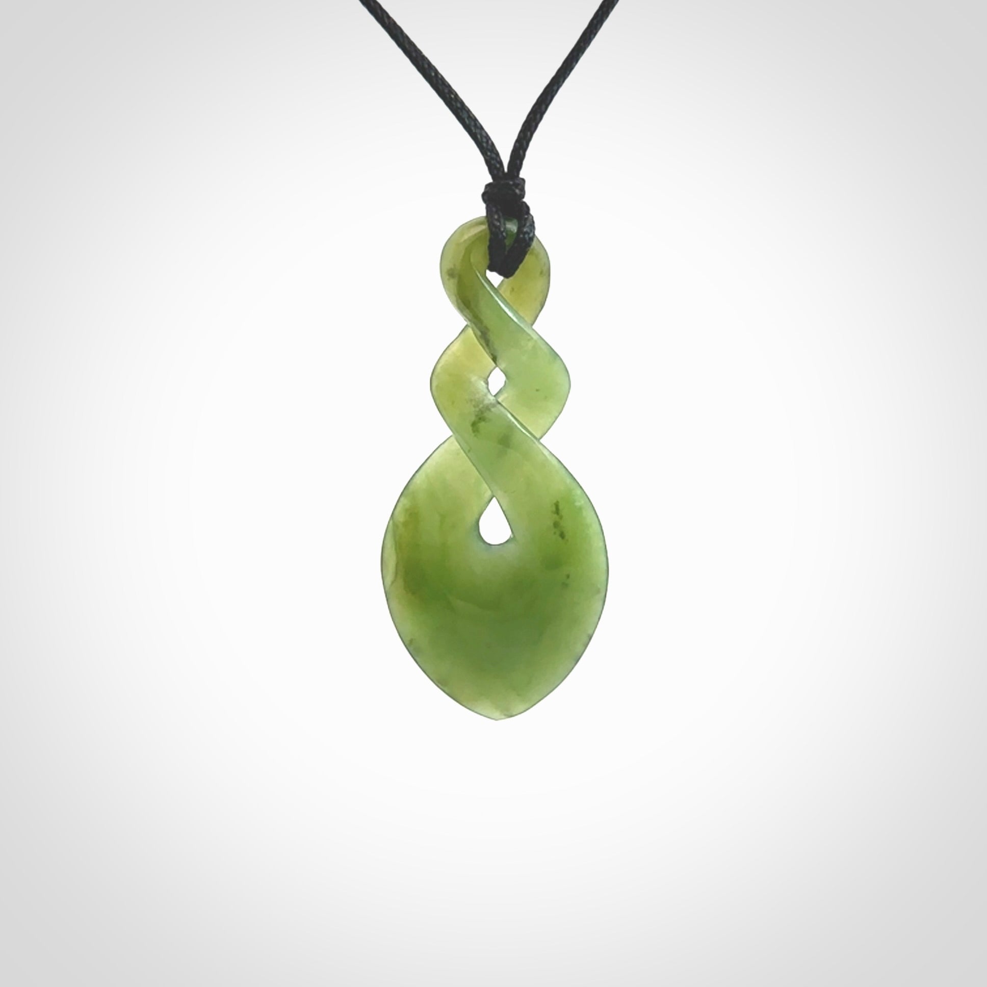 Hand carved New Zealand jade twist pendant. Carved in New Zealand by NZ Pacific. Unique double twist jewellery for sale online. Provided with an adjustable black cord.