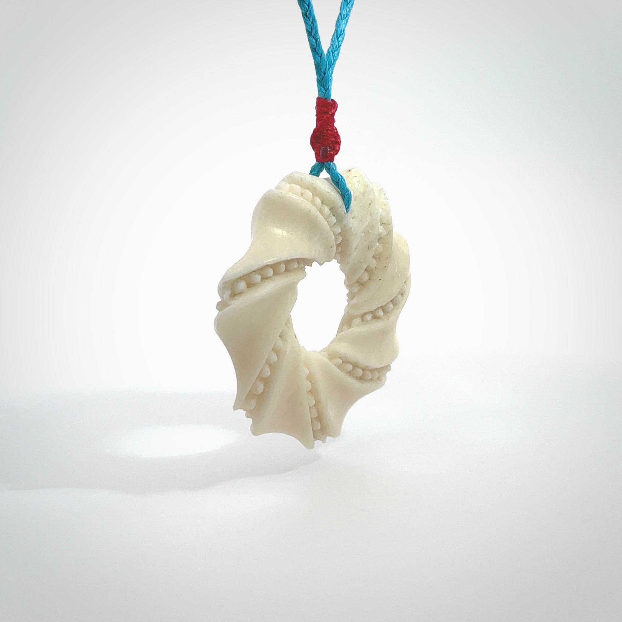 A hand carved masterpiece. A beautiful contemporary pendant carved from bone by Yuri Terenyi for NZ Pacific. This is a true piece of wearable art which is collectible. A one-off masterpiece and quite unique. Provided with an adjustable paradise blue cord and packaged in a woven kete pouch.