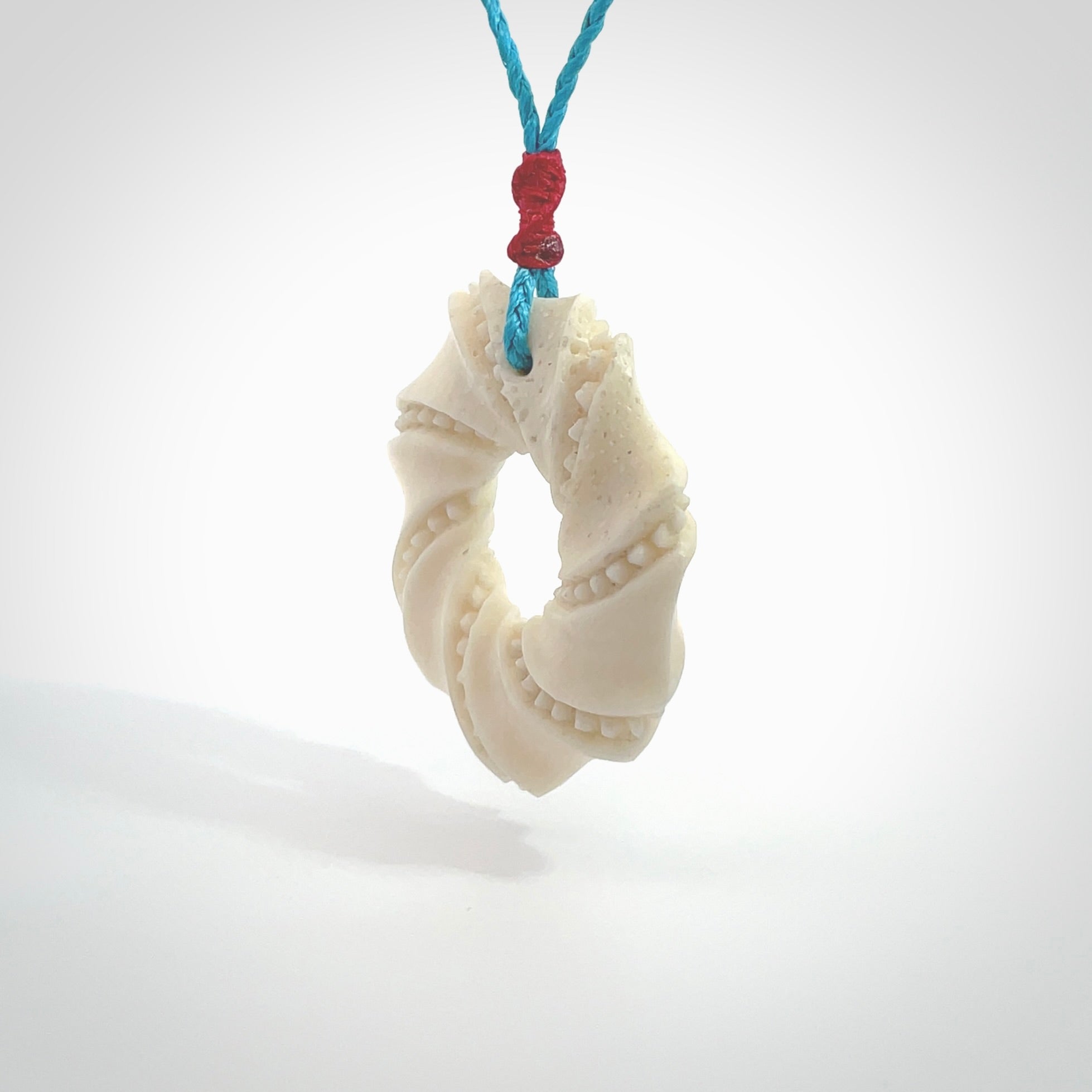 A hand carved masterpiece. A beautiful contemporary pendant carved from bone by Yuri Terenyi for NZ Pacific. This is a true piece of wearable art which is collectible. A one-off masterpiece and quite unique. Provided with an adjustable paradise blue cord and packaged in a woven kete pouch.