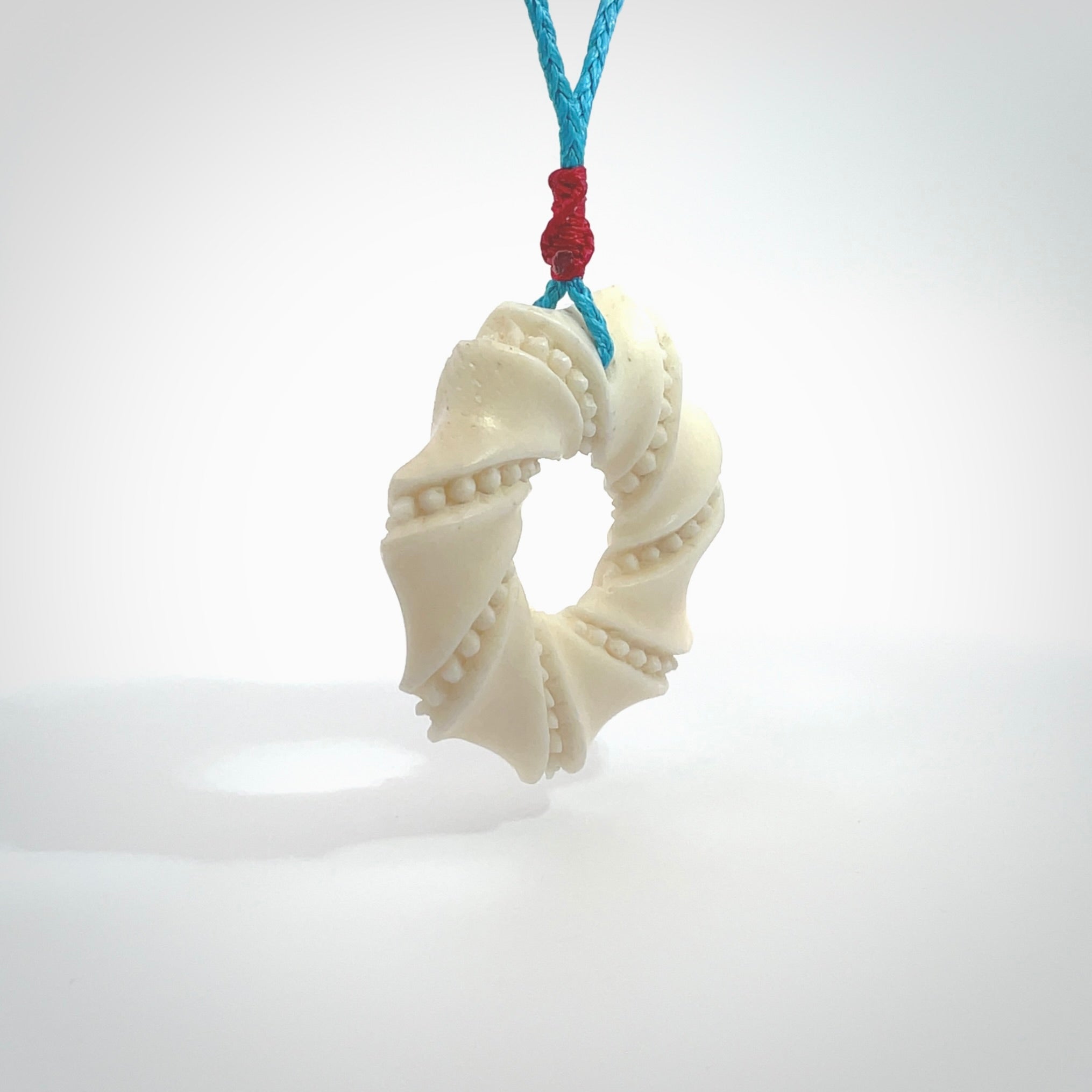 A hand carved masterpiece. A beautiful contemporary pendant carved from bone by Yuri Terenyi for NZ Pacific. This is a true piece of wearable art which is collectible. A one-off masterpiece and quite unique. Provided with an adjustable paradise blue cord and packaged in a woven kete pouch.