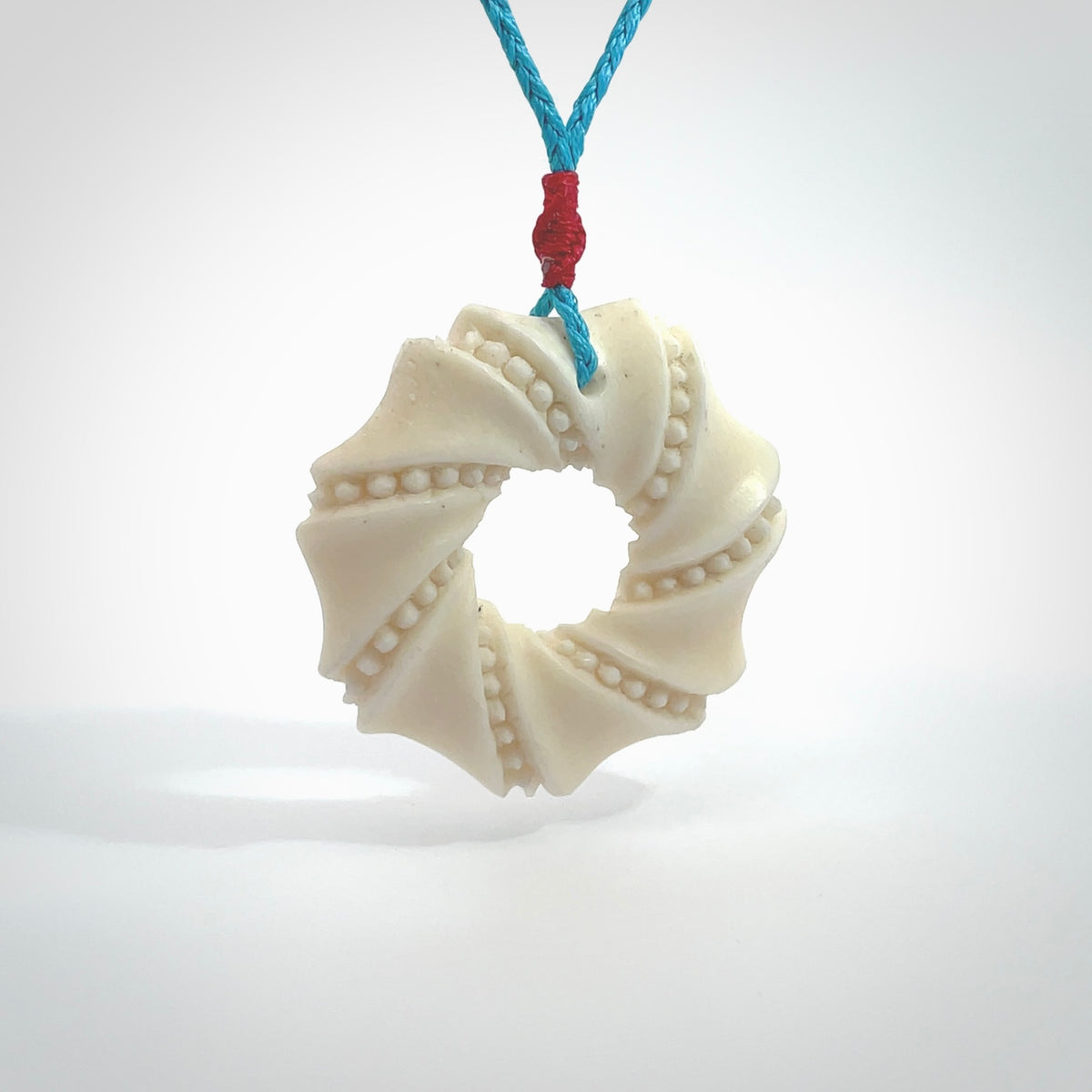 A hand carved masterpiece. A beautiful contemporary pendant carved from bone by Yuri Terenyi for NZ Pacific. This is a true piece of wearable art which is collectible. A one-off masterpiece and quite unique. Provided with an adjustable paradise blue cord and packaged in a woven kete pouch.