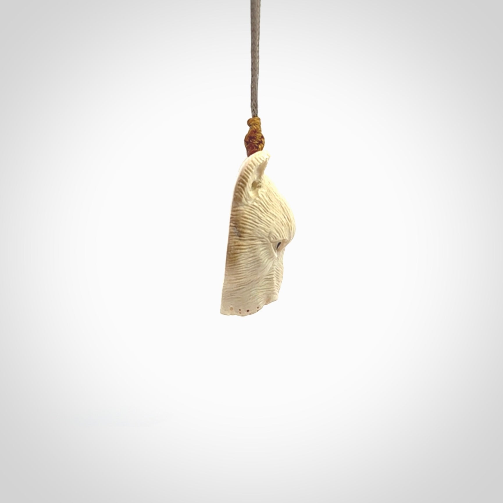 This pendant is a hand carved puma. We've carved this from a lovely piece of woolly mammoth tusk and we provide it with a hand plaited cord. Shipping is free worldwide.