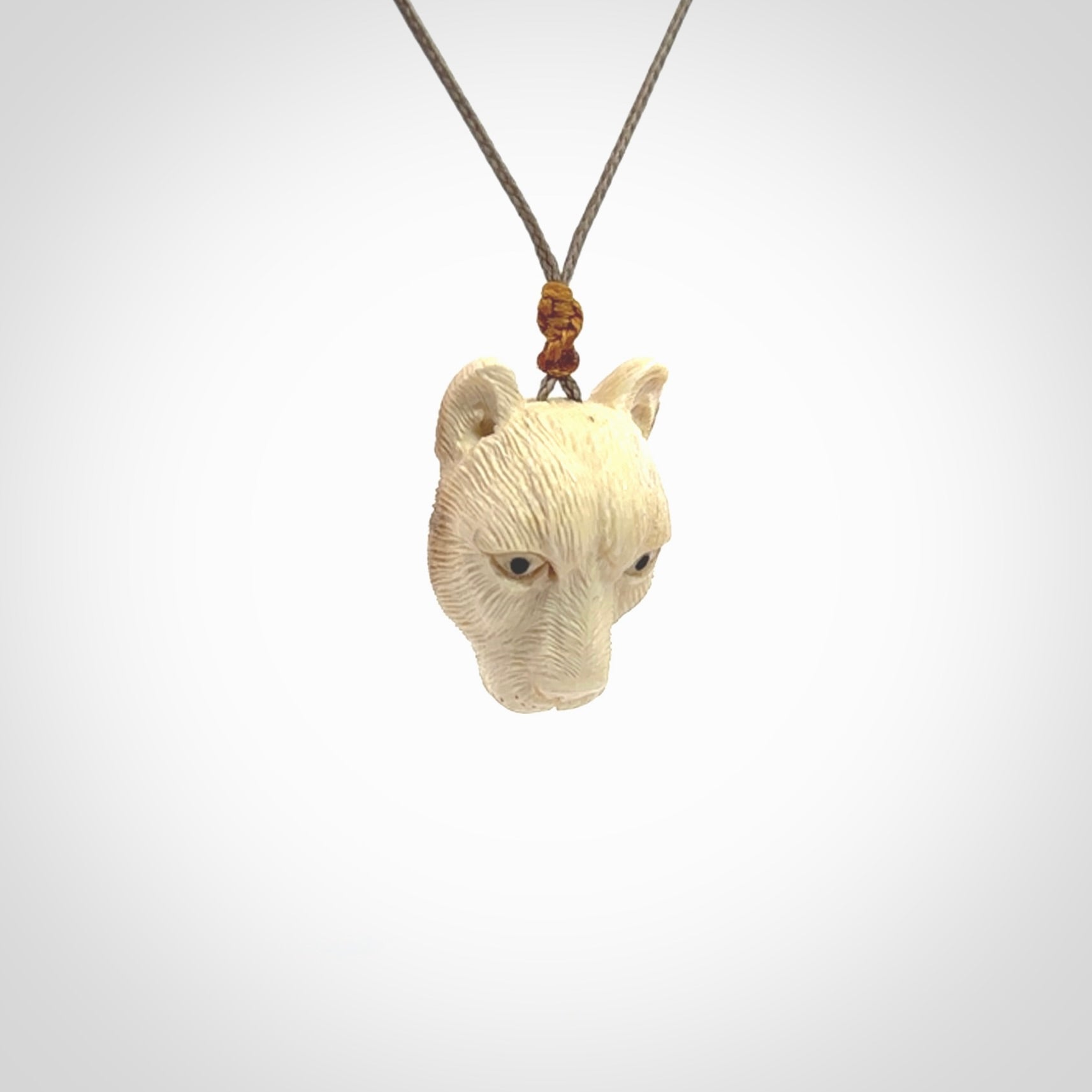 This pendant is a hand carved puma. We've carved this from a lovely piece of woolly mammoth tusk and we provide it with a hand plaited cord. Shipping is free worldwide.