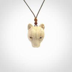 This pendant is a hand carved puma. We've carved this from a lovely piece of woolly mammoth tusk and we provide it with a hand plaited cord. Shipping is free worldwide.