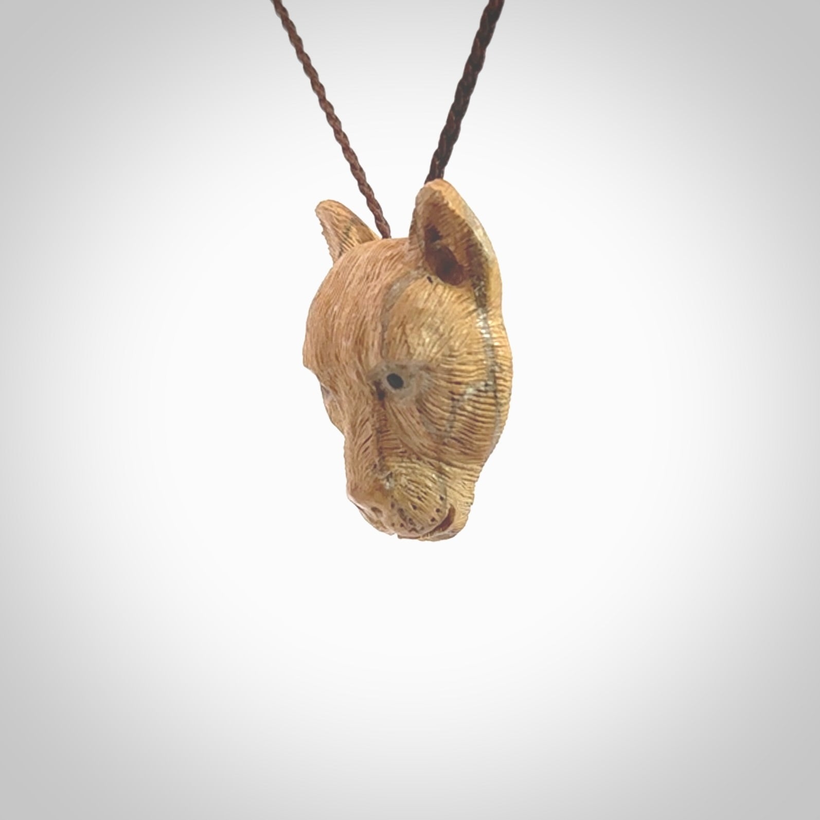 This pendant is a hand carved puma. We've carved this from a lovely piece of woolly mammoth tusk and we provide it with a hand plaited cord. Shipping is free worldwide.