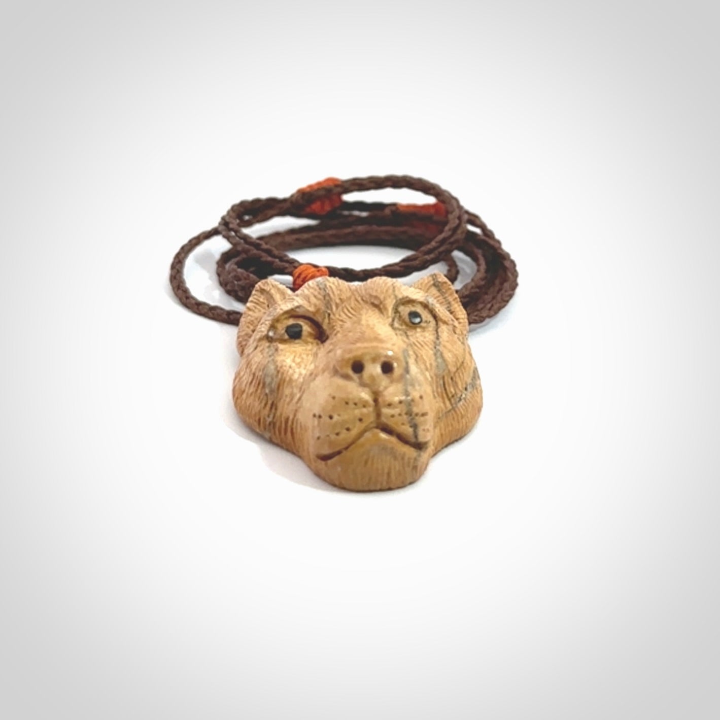 This pendant is a hand carved puma. We've carved this from a lovely piece of woolly mammoth tusk and we provide it with a hand plaited cord. Shipping is free worldwide.