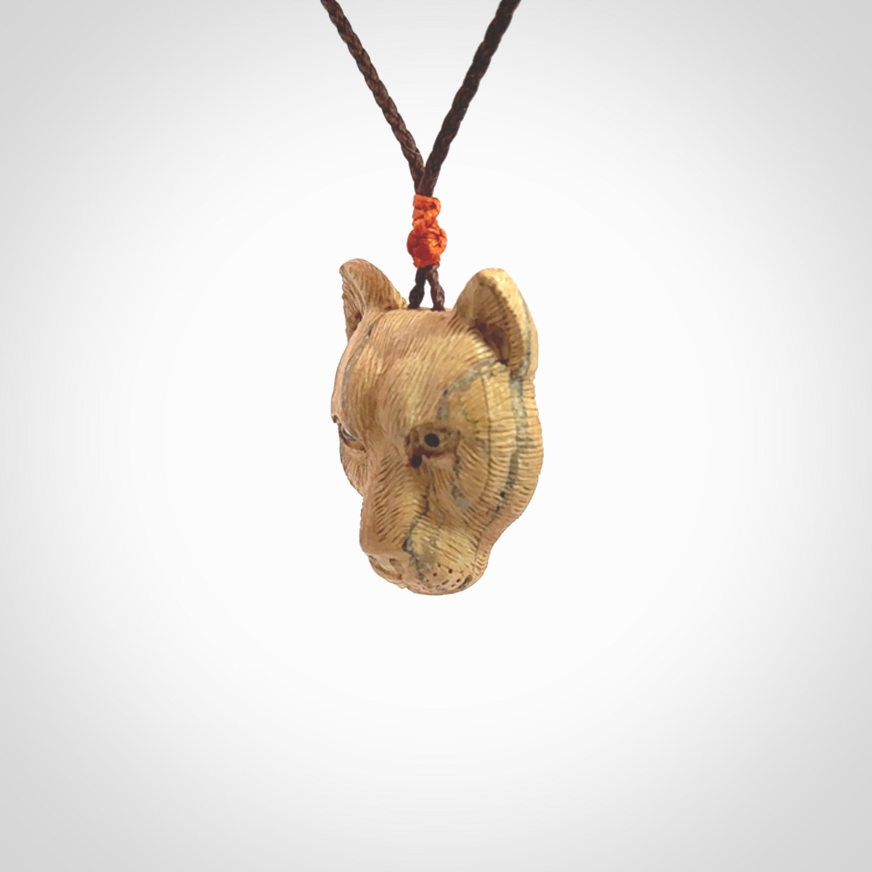 This pendant is a hand carved puma. We've carved this from a lovely piece of woolly mammoth tusk and we provide it with a hand plaited cord. Shipping is free worldwide.