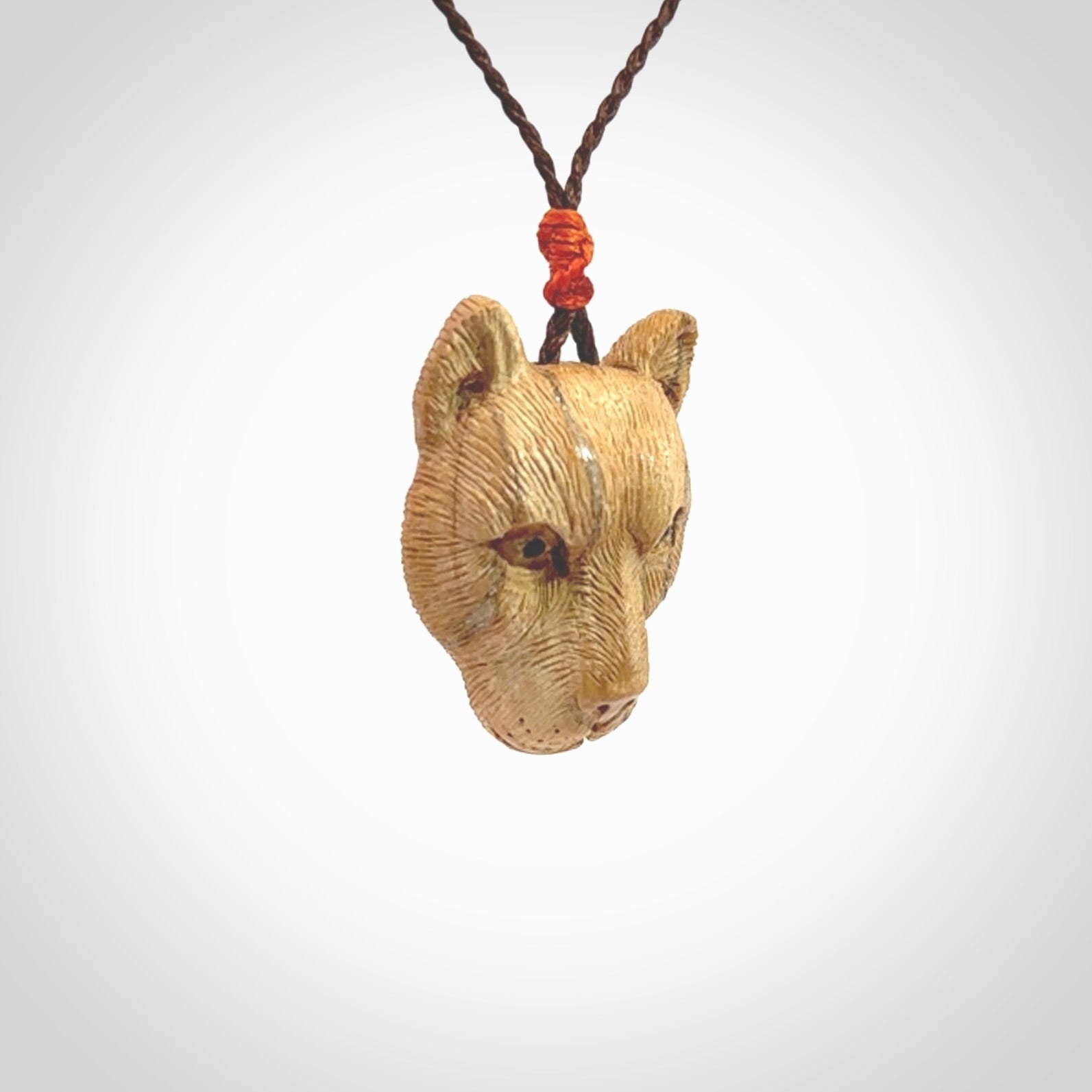 This pendant is a hand carved puma. We've carved this from a lovely piece of woolly mammoth tusk and we provide it with a hand plaited cord. Shipping is free worldwide.