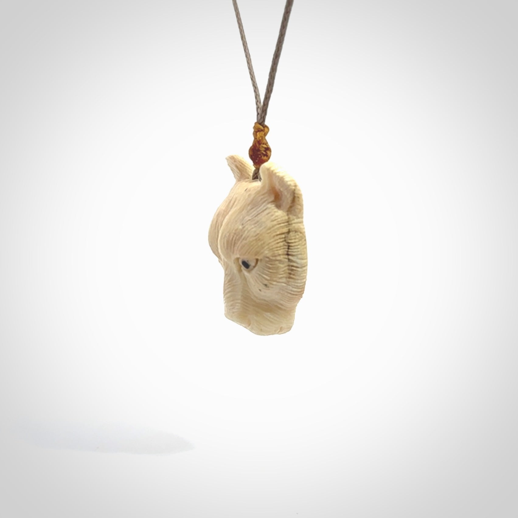 This pendant is a hand carved puma. We've carved this from a lovely piece of woolly mammoth tusk and we provide it with a hand plaited cord. Shipping is free worldwide.