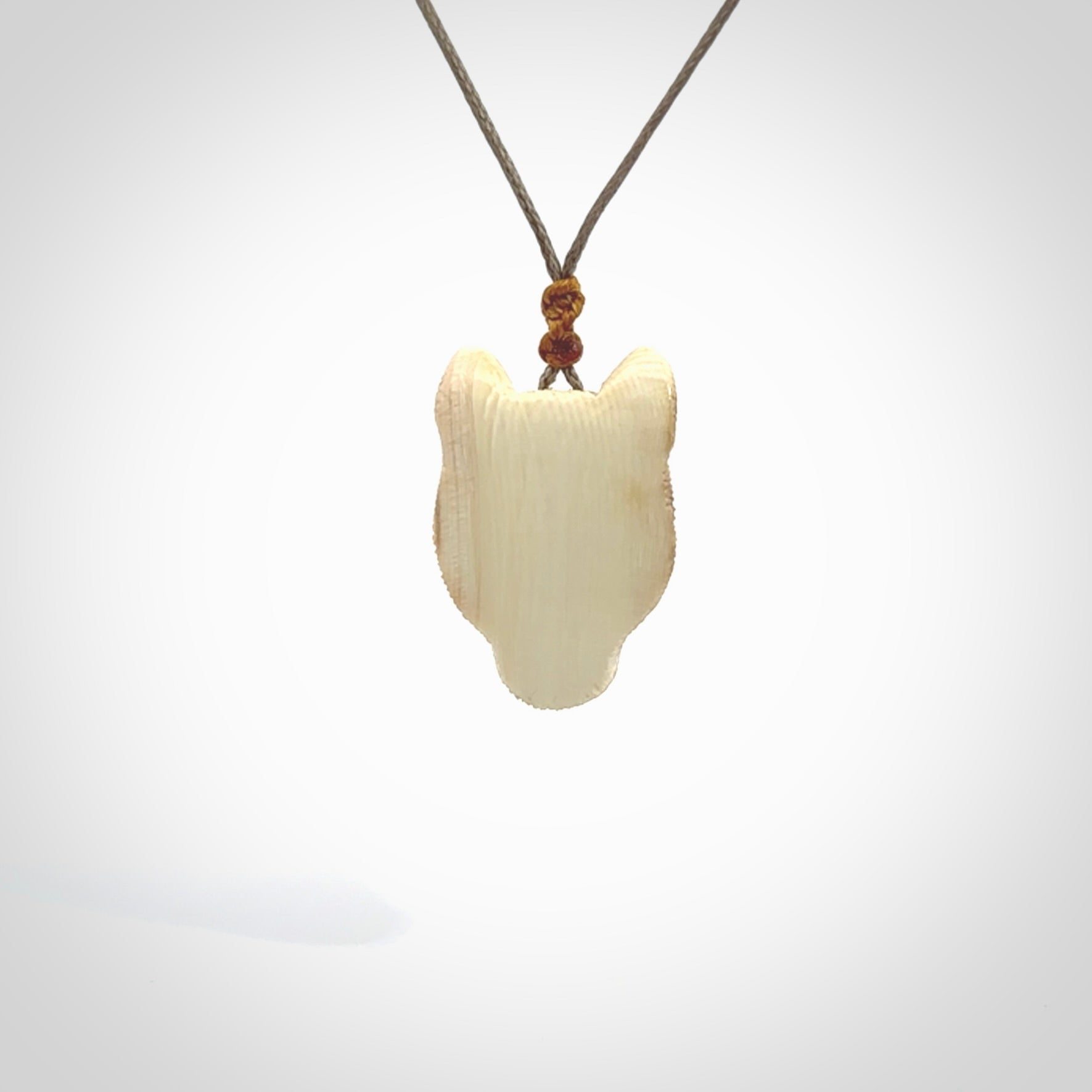 This pendant is a hand carved puma. We've carved this from a lovely piece of woolly mammoth tusk and we provide it with a hand plaited cord. Shipping is free worldwide.