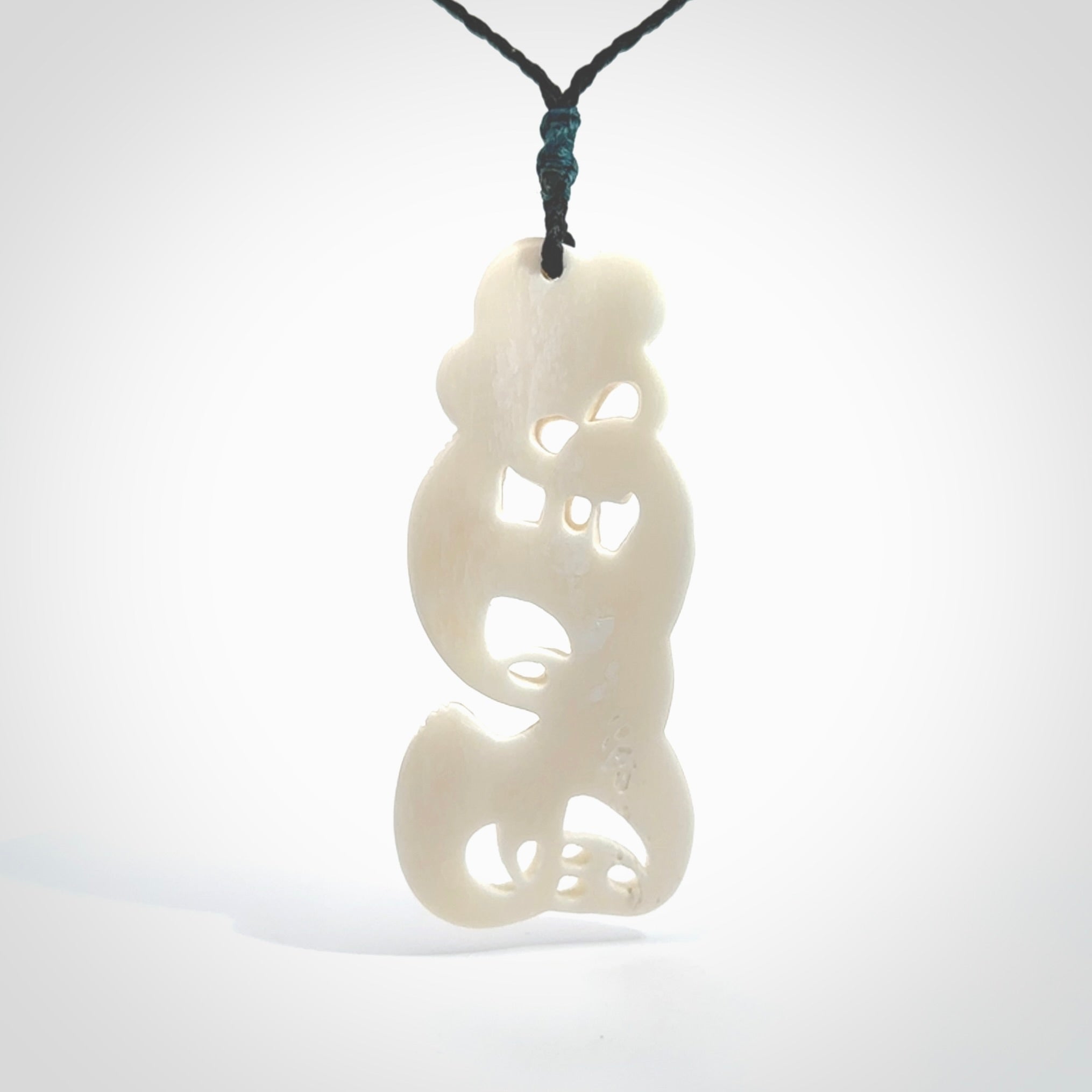 Hand carved bone Tiki pendant. Traditional art hand carved for NZ Pacific. Bone Tiki necklace with Paua Shell eyes. Delivered with Express Courier. Provided with adjustable cords and packaged in a woven kete pouch.