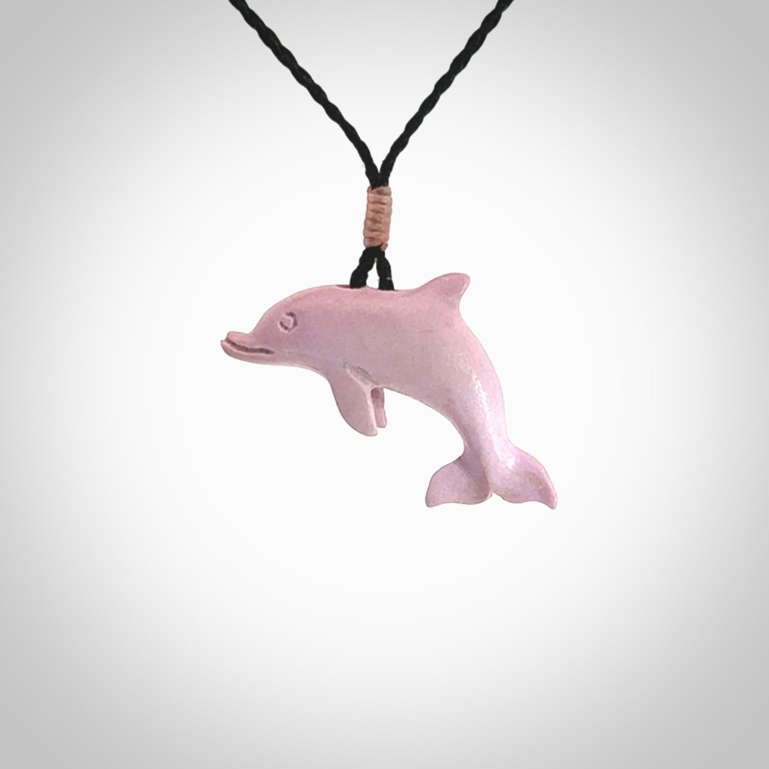 This is a hand carved dolphin pendant made from a gorgeous and striking piece of Pink Opal stone. This is a superbly carved and very unique dolphin necklace. For sale online from NZ Pacific. Delivered with adjustable cord.