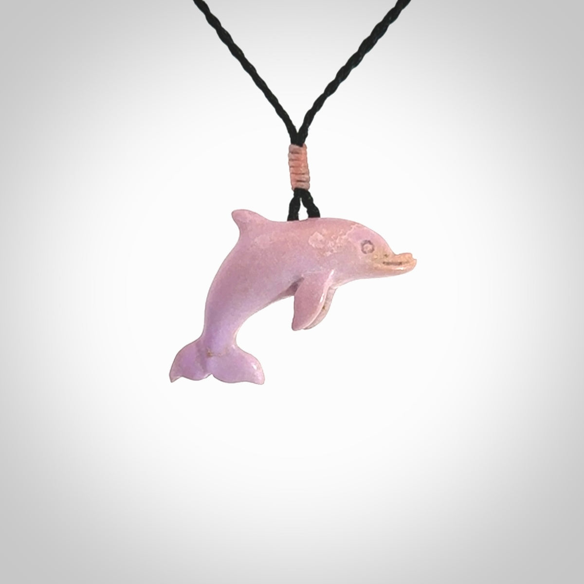 This is a hand carved dolphin pendant made from a gorgeous and striking piece of Pink Opal stone. This is a superbly carved and very unique dolphin necklace. For sale online from NZ Pacific. Delivered with adjustable cord.