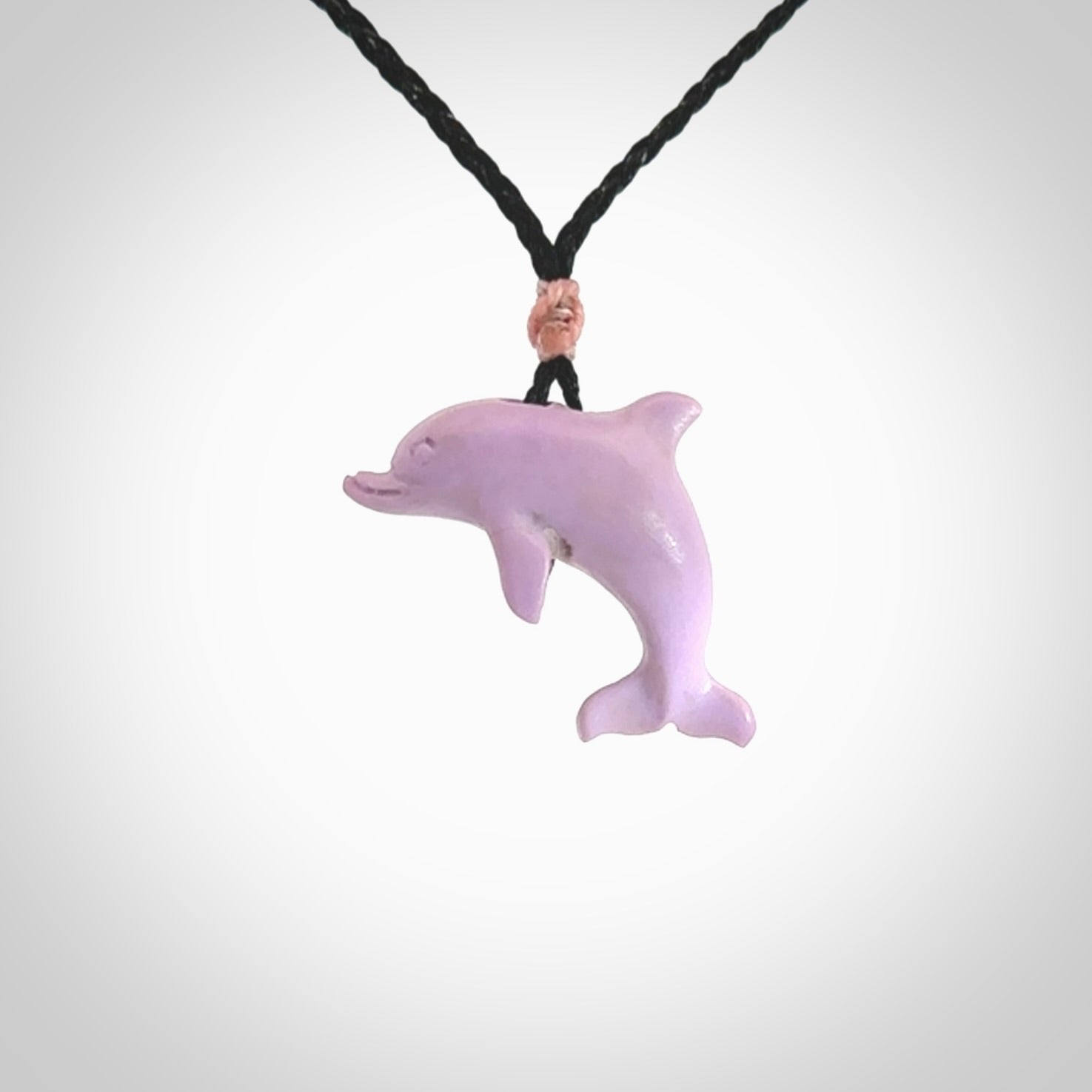 This is a hand carved dolphin pendant made from a gorgeous and striking piece of Pink Opal stone. This is a superbly carved and very unique dolphin necklace. For sale online from NZ Pacific. Delivered with adjustable cord.