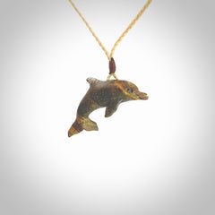 This is a hand carved dolphin pendant made from a gorgeous and striking piece of Tiger Iron. This is a superbly carved and very unique dolphin necklace. For sale online from NZ Pacific. Delivered with adjustable cord.