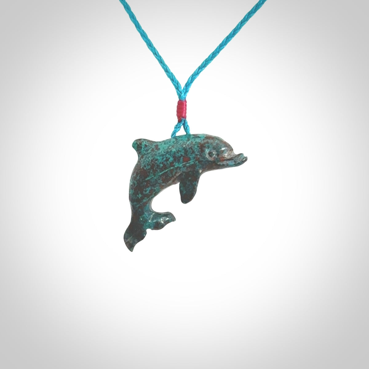 This is a hand carved dolphin pendant made from a gorgeous and striking piece of African Turquoise stone. This is a superbly carved and very unique dolphin necklace. For sale online from NZ Pacific. Delivered with adjustable cord.