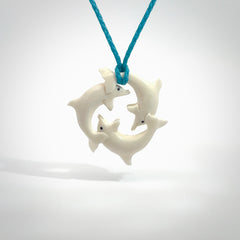 Hand carved dolphin trio pendant, made from natural bone by NZ Pacific. Hand made natural bone dolphin trilogy necklace, provided with an adjustable paradise blue cord. Packaged in a woven kete pouch.