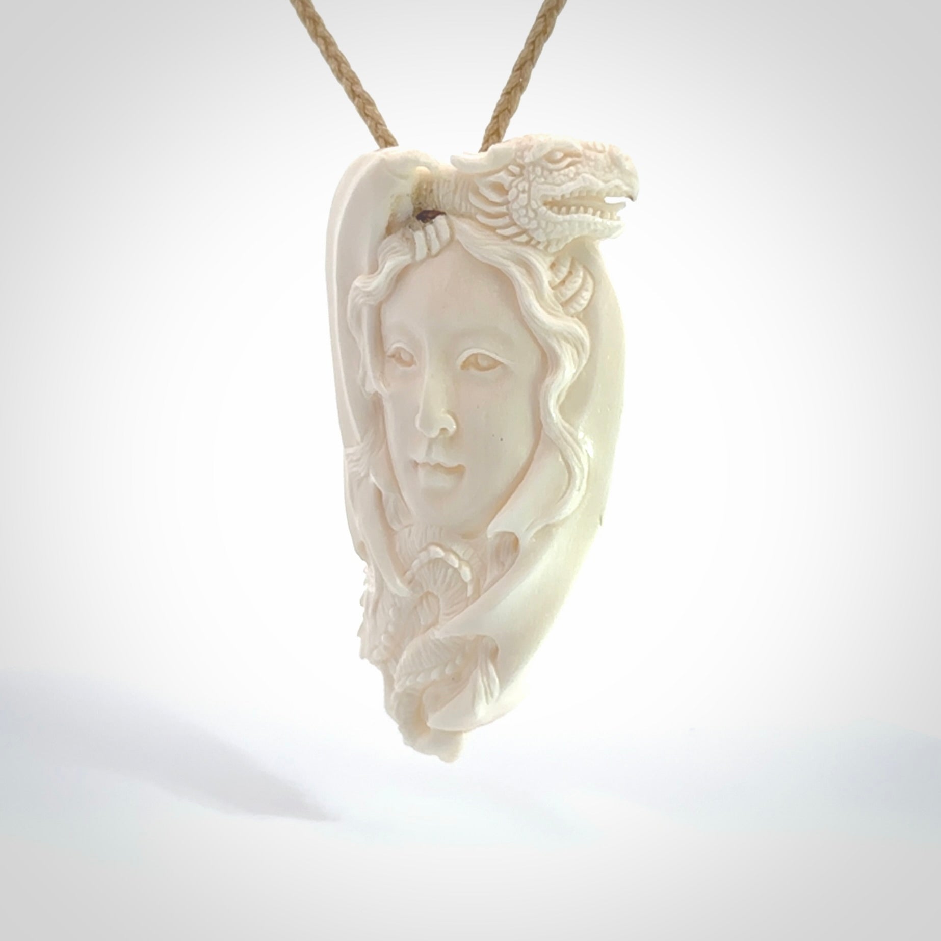 This is a hand carved bone woman with dragon pendant. It is made from bone and has an adjustable oat coloured cord. This is a large sized necklace and is a very unique, one only, pendant that is a piece for art lovers. One only pendant.