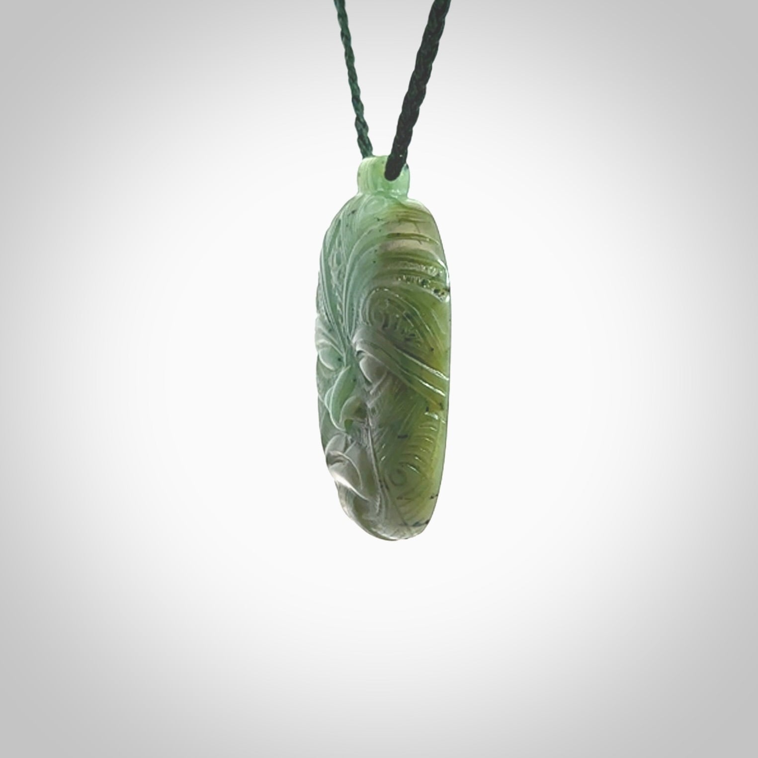 This picture shows a hand carved Jade face pendant. It is a varied green colour which is quite beautiful. Although a medium piece, it is a wonderful, delicate piece of jewellery. The cord is hand plaited and adjustable so that you can position the pendant where it suits you best. Delivery is free worldwide.