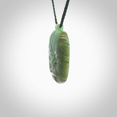 This picture shows a hand carved Jade face pendant. It is a varied green colour which is quite beautiful. Although a medium piece, it is a wonderful, delicate piece of jewellery. The cord is hand plaited and adjustable so that you can position the pendant where it suits you best. Delivery is free worldwide.