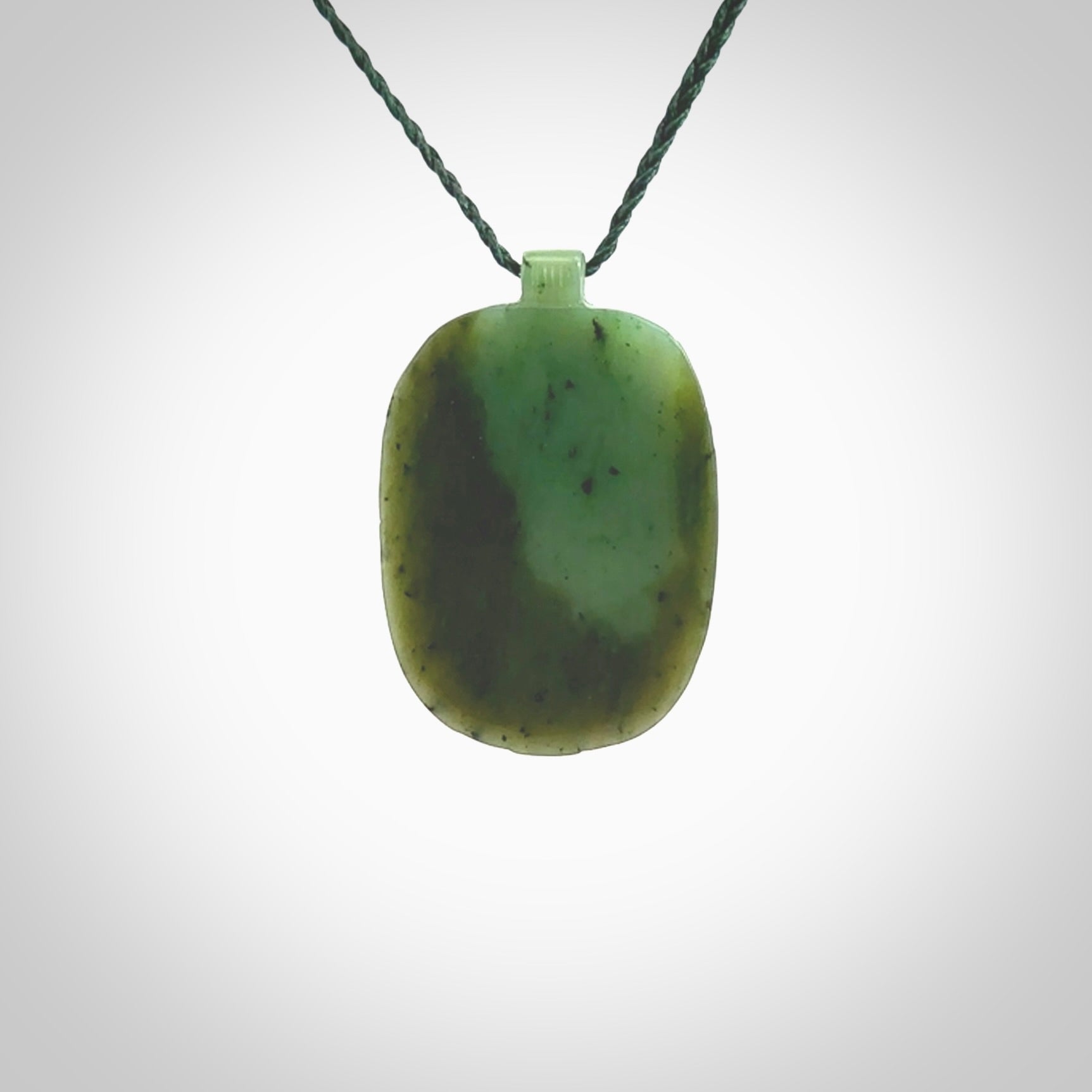 This picture shows a hand carved Jade face pendant. It is a varied green colour which is quite beautiful. Although a medium piece, it is a wonderful, delicate piece of jewellery. The cord is hand plaited and adjustable so that you can position the pendant where it suits you best. Delivery is free worldwide.